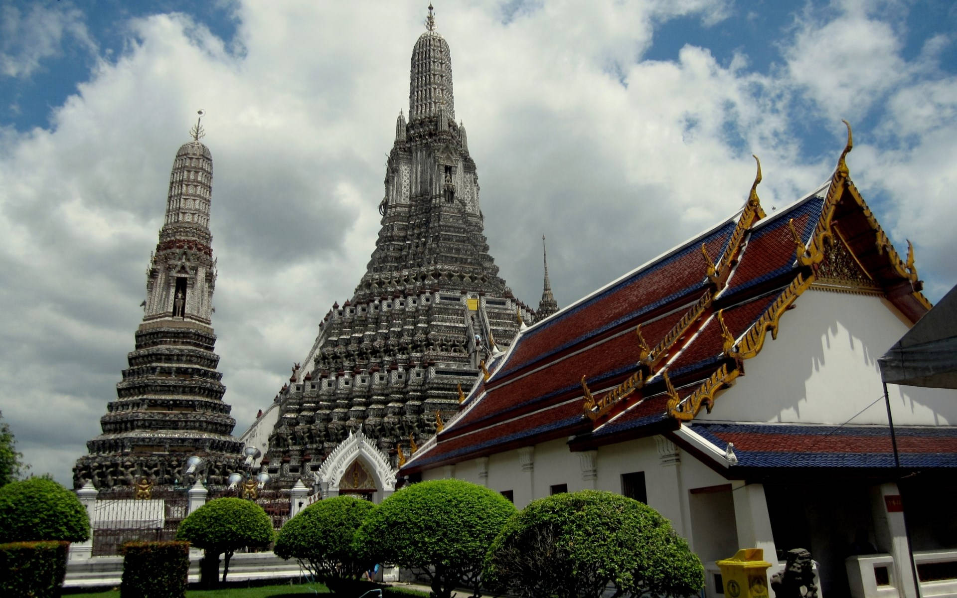 Bangkok 桌布 壁紙 — 宏偉的泰國寺廟，擁有華麗的尖頂和金色屋頂，襯托著多雲的藍天。