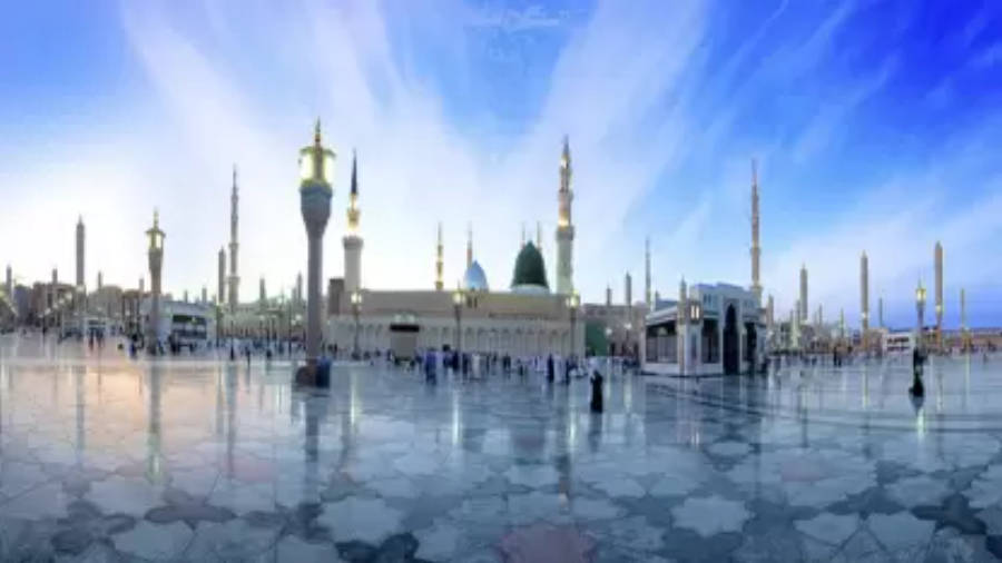 Madina 桌布 壁紙 — 宏偉的清真寺，高聳的宣禮塔和圓頂倒映在廣闊的濕潤庭院中，上方是充滿活力的藍天。