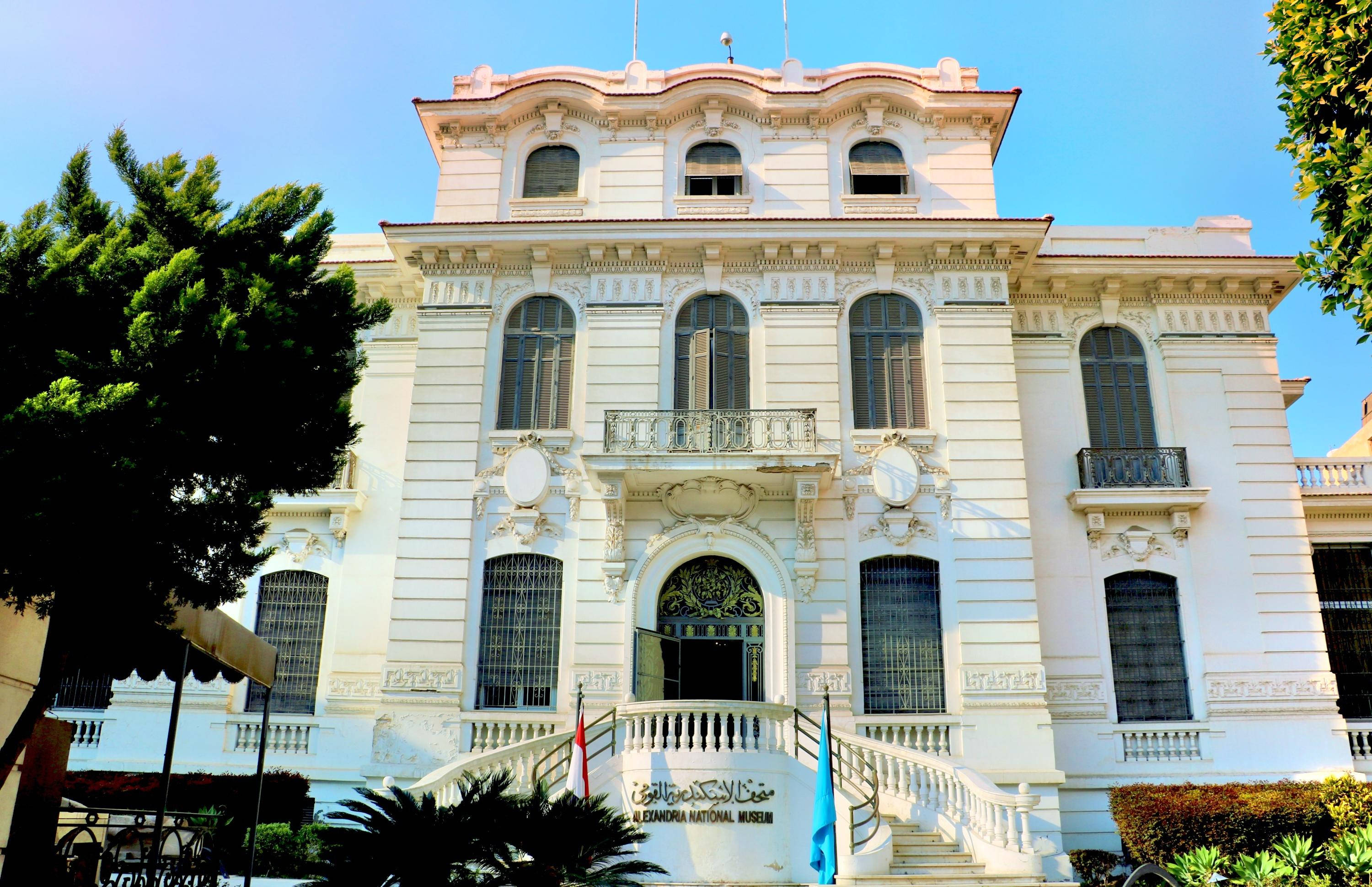 Alexandria 桌布 壁紙 — 宏偉的白色新古典主義博物館建築，擁有華麗的陽台和拱形窗戶，在清澈的藍天下。