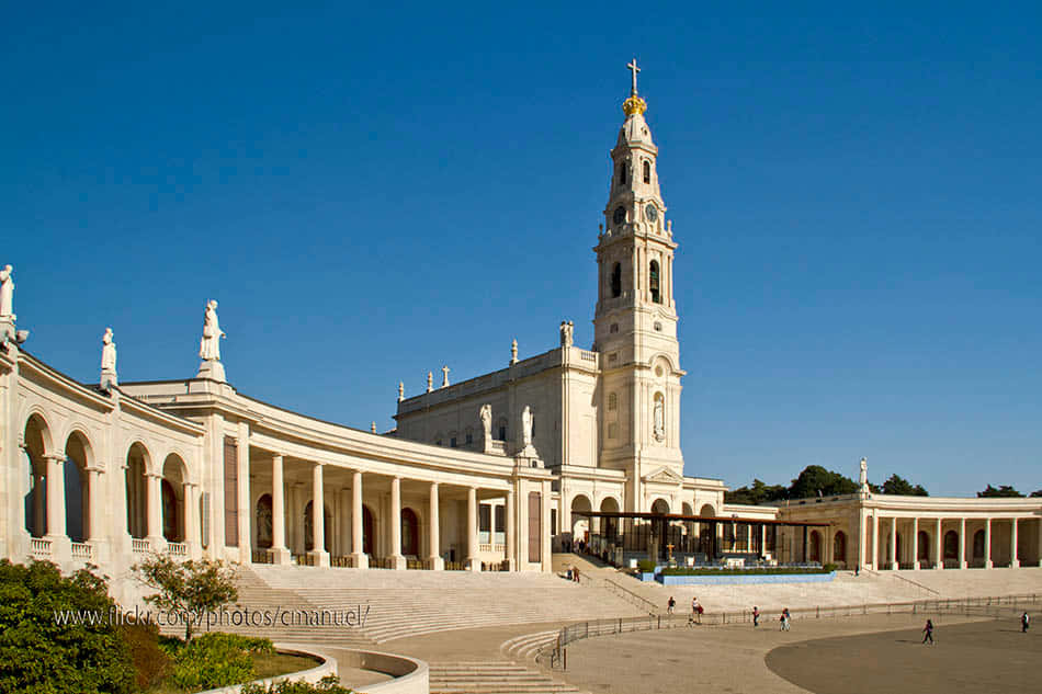 Portugal 桌布 壁紙 — 宏偉的白色石造大教堂，擁有高聳鐘樓和雕像，在清澈藍天下。