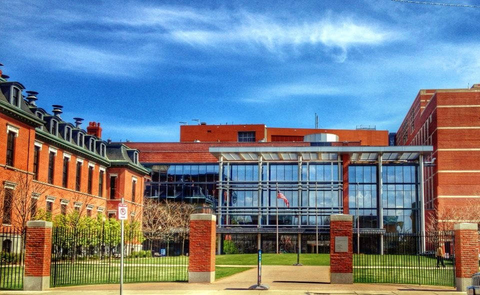 Building 桌布 壁紙 — 宏偉的磚造大學校園，玻璃幕牆的現代建築，在湛藍天空和縷縷白雲下。