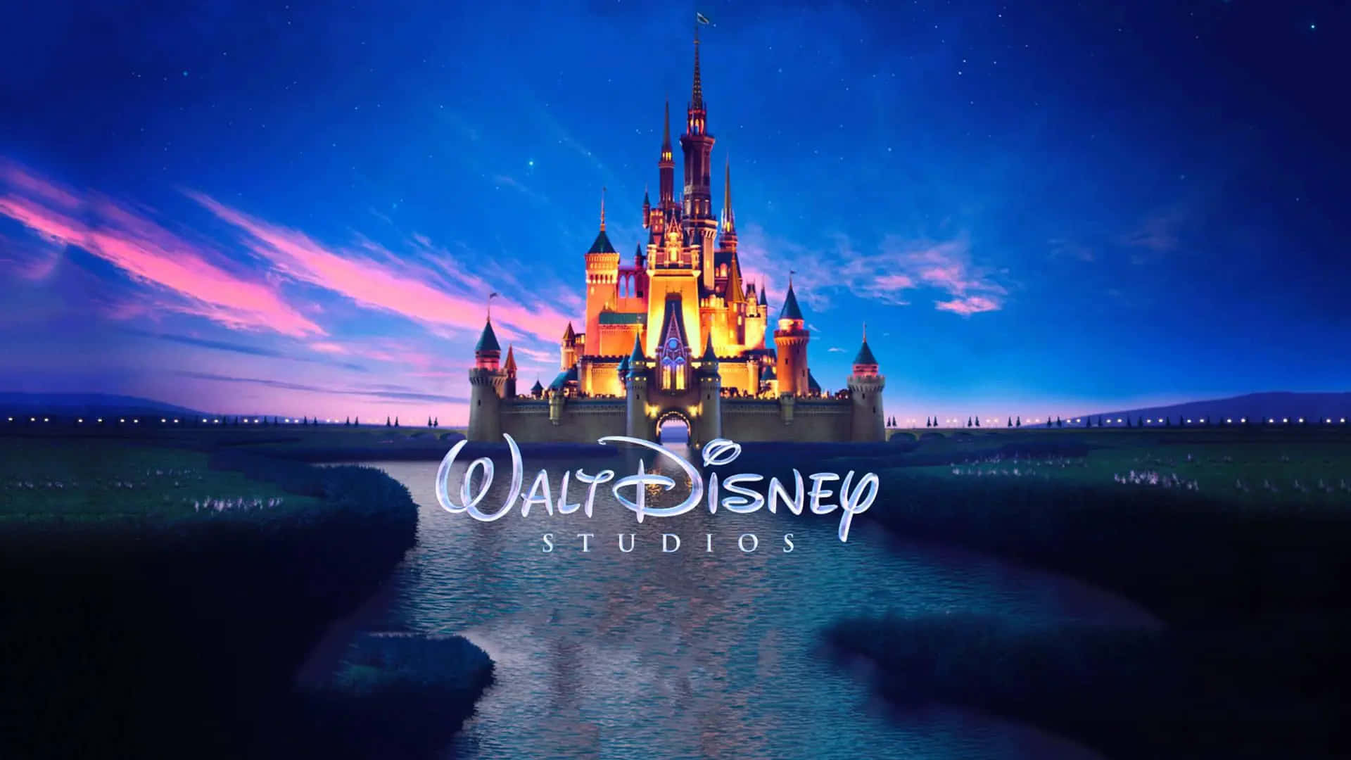 Walt Disney Studios Motion 桌布 壁紙 — 宏偉的迪士尼城堡在佈滿粉紅色和紫色雲彩的暮色天空下溫暖地發光。