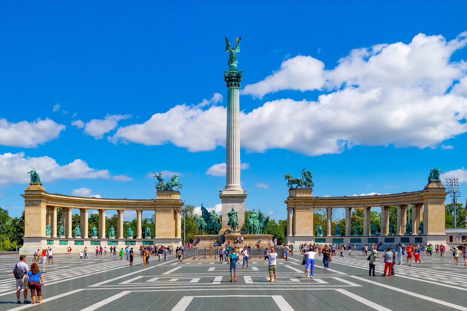Hungary 桌布 壁紙 — 宏偉紀念碑，高聳的柱子和青銅雕像，在晴朗藍天和蓬鬆白雲下。