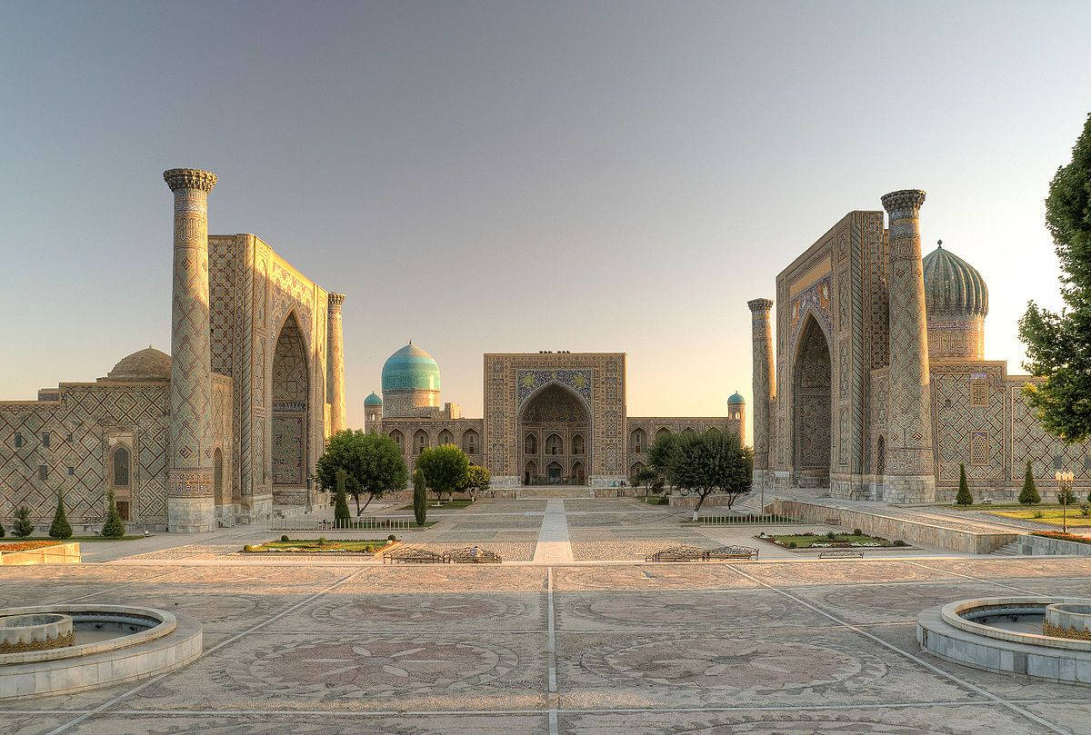 Uzbekistan 桌布 壁紙 — 宏大的伊斯蘭建築群，藍綠色圓頂和宣禮塔沐浴在金色的日出光芒中。