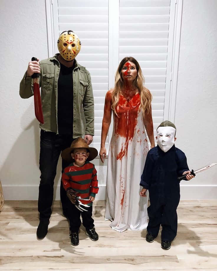 Creepy Halloween 桌布 壁紙 — 家庭打扮成恐怖電影反派，在室內用假血和道具擺姿勢。