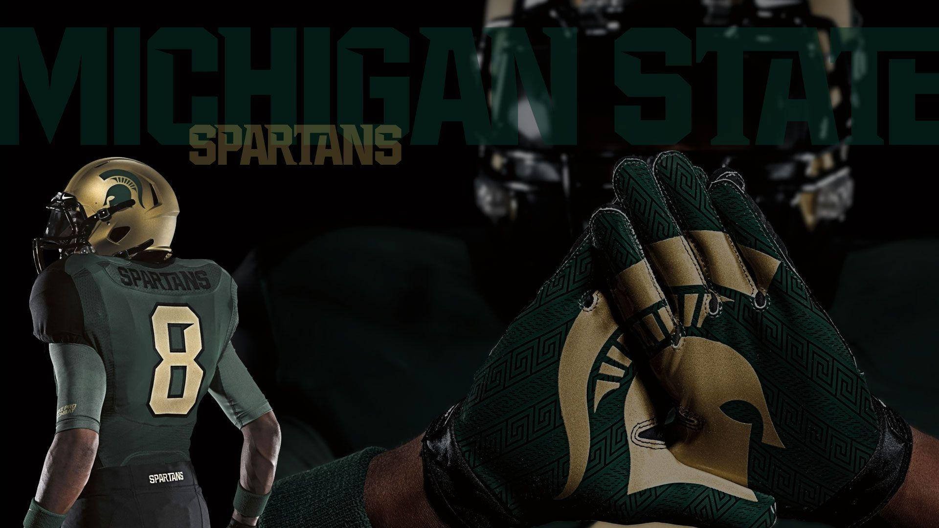 Michigan State Spartans 桌布 壁紙 — 密西根州立大學斯巴達人隊的足球員身穿綠色和金色裝備，站在一隻戴著手套、展示球隊標誌的手的特寫旁邊。