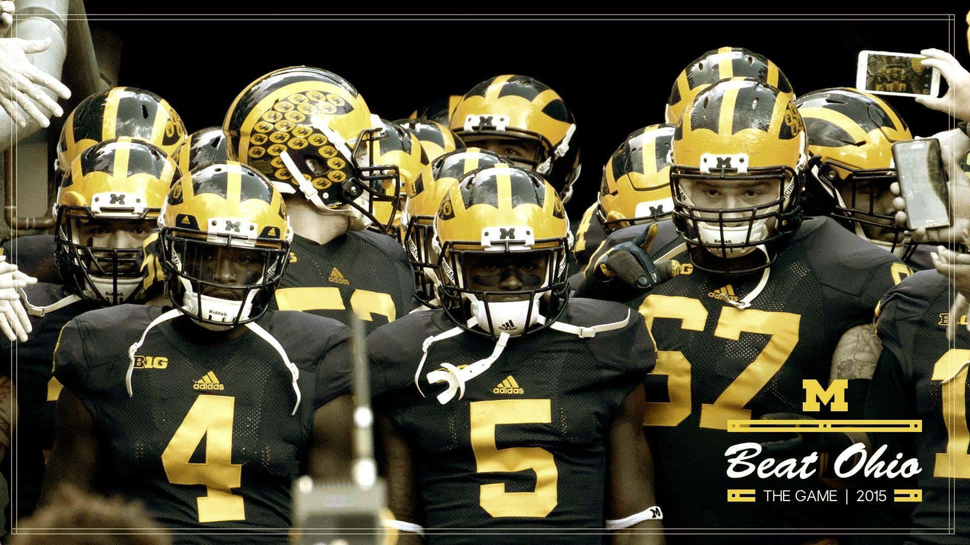 Michigan Football 桌布 壁紙 — 密西根足球隊員身穿黑色和金色制服，在比賽前激烈地圍在一起，可見「Beat Ohio」字樣。
