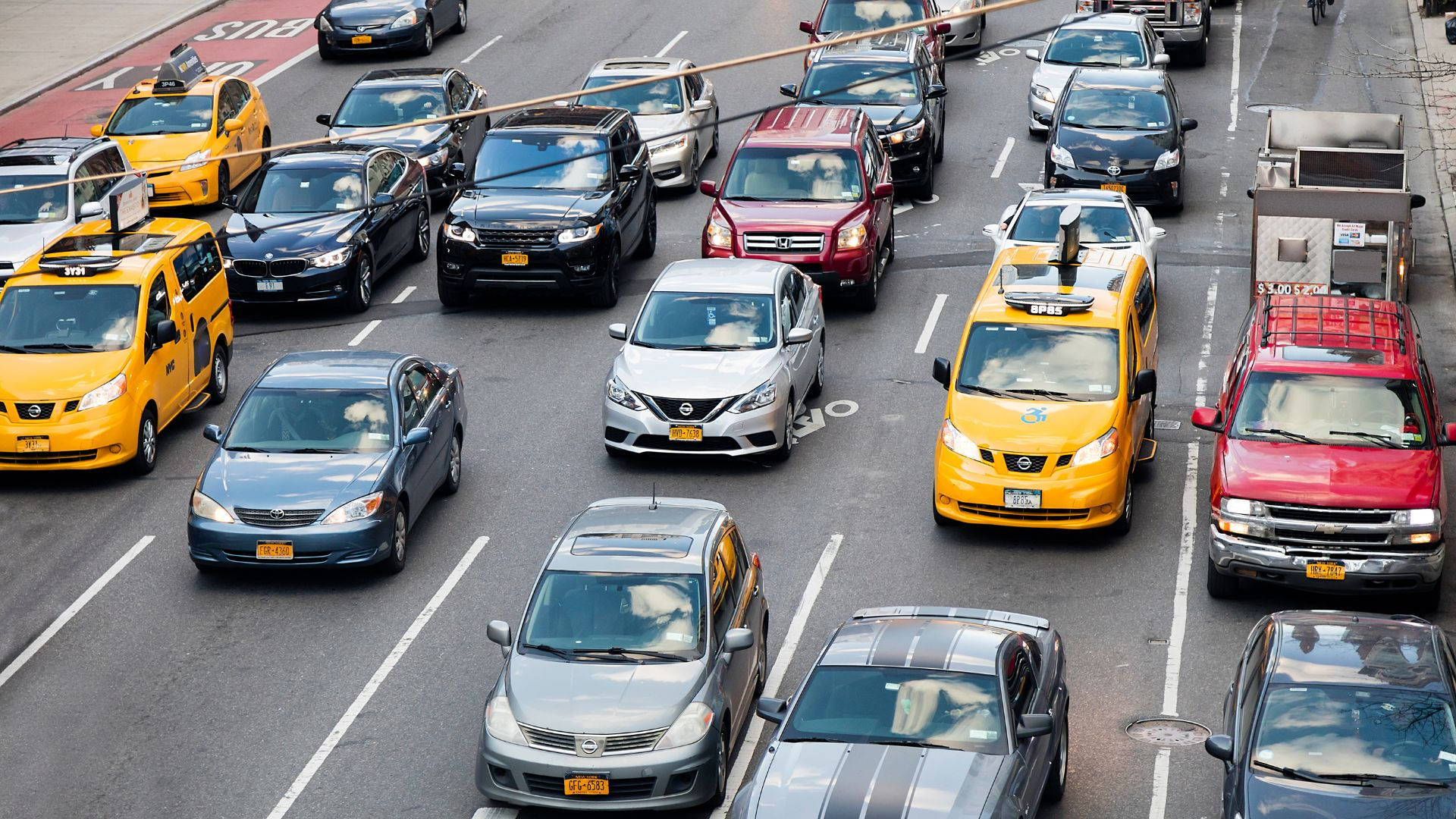 Road 桌布 壁紙 — 密集城市交通的鳥瞰圖，黃色計程車和各種汽車擠滿多車道城市街道。