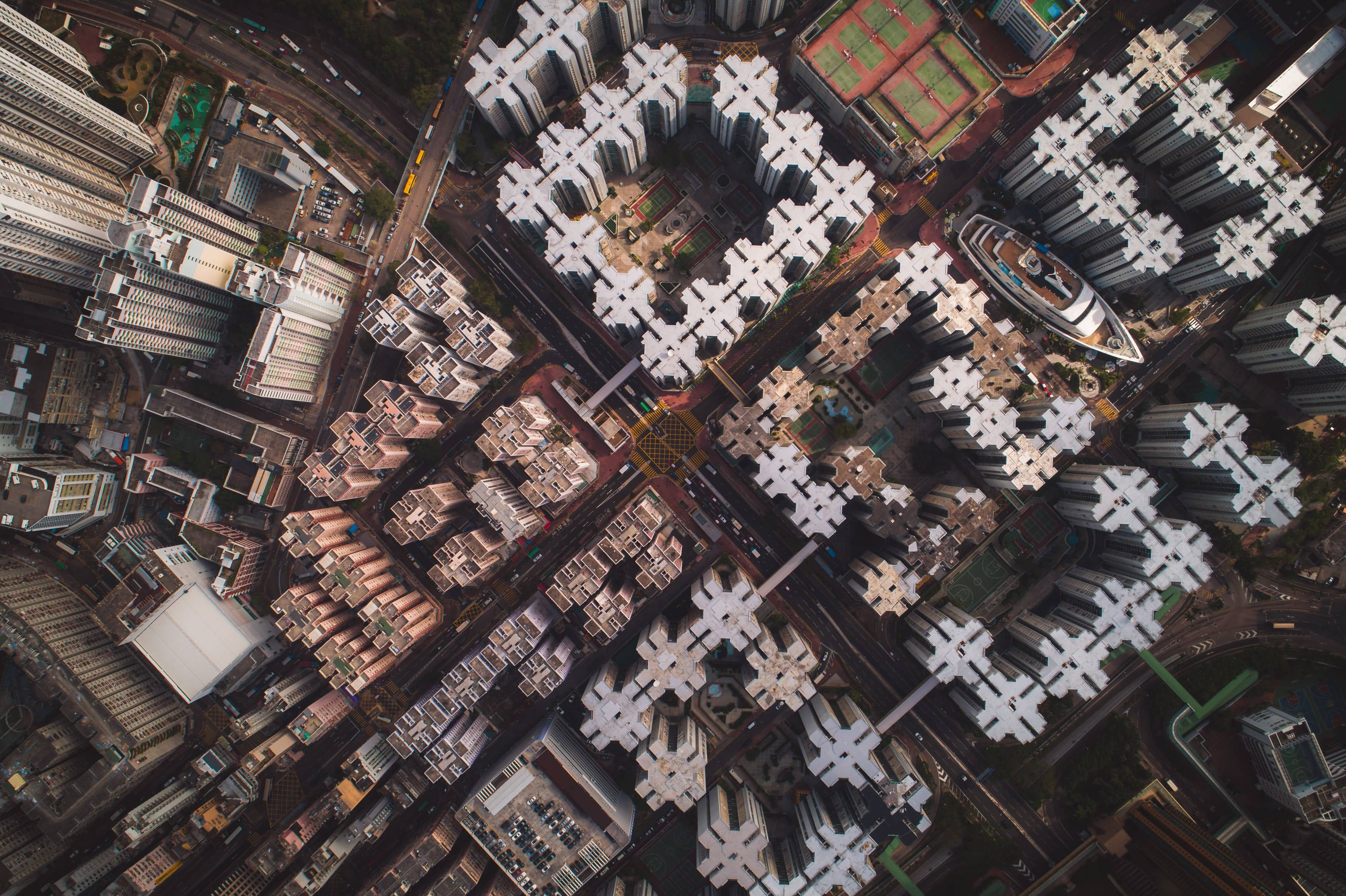 View 桌布 壁紙 — 密集城市天際線的鳥瞰圖，下方有重複的高層公寓樓群和蜿蜒的街道。