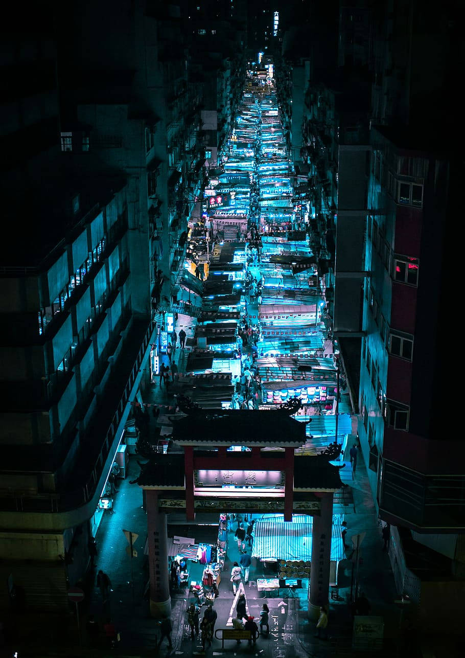 唐人街 桌布 壁紙 — 密集市區中一條繁華的霓虹燈夜市街道的鳥瞰圖，有發光的攤位和行人。