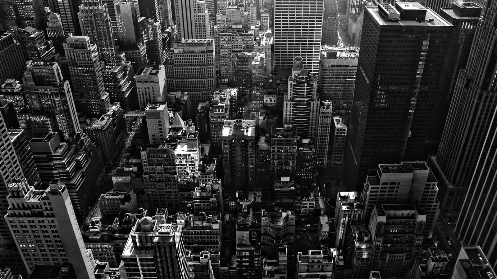 Black And White Architecture 桌布 壁紙 — 密集摩天大樓的航拍黑白照片，展現廣闊都市大都會中銳利的幾何線條和深邃陰影。
