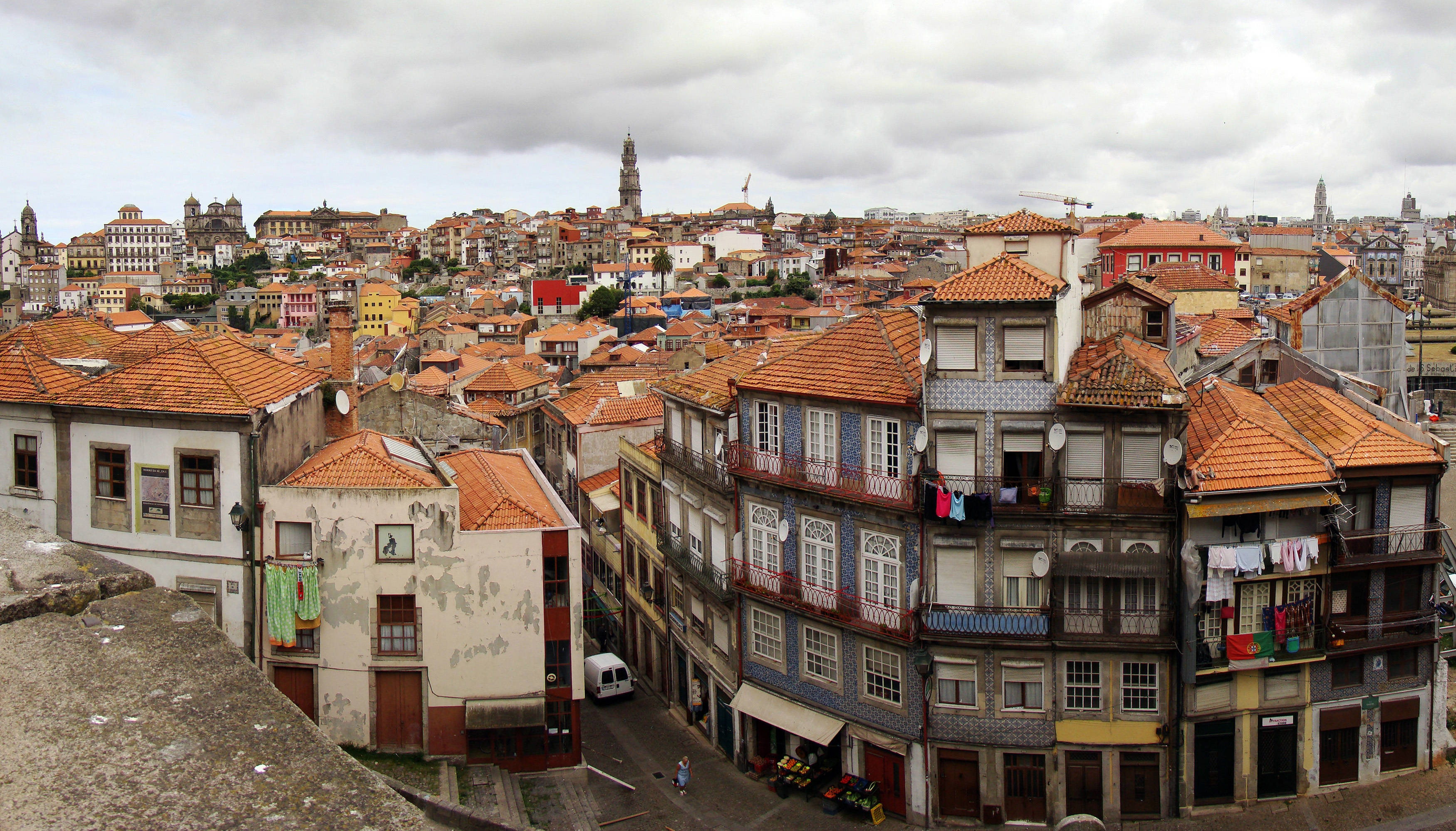 Portugal 桌布 壁紙 — 密集歐洲城市景觀的鳥瞰圖，有陶土屋頂、色彩繽紛的外牆，以及陰天時掛在陽台上的衣物。