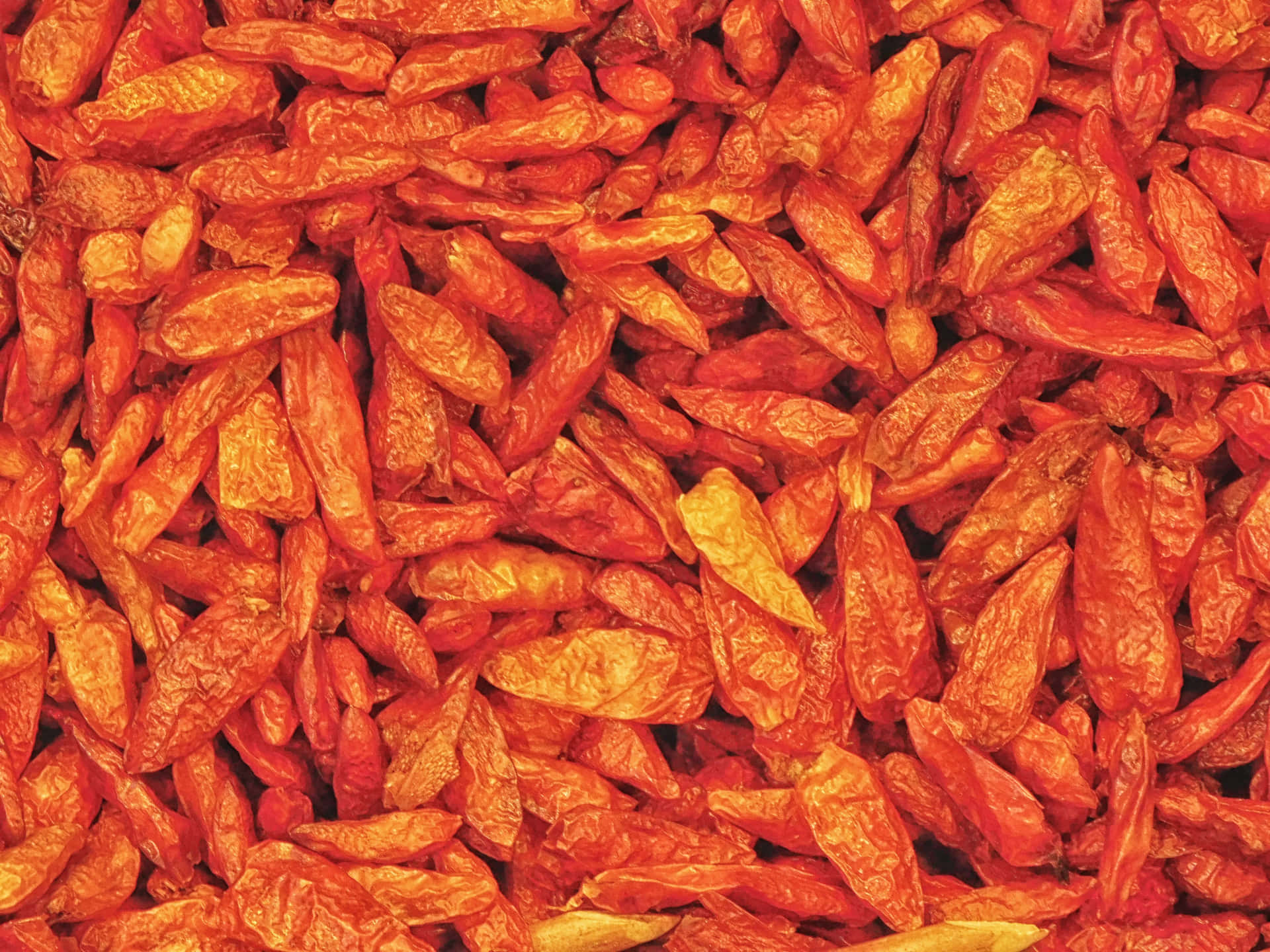 Chili 壁紙 — 密集的乾皺紅辣椒特寫，帶有溫暖的橙色高光。
