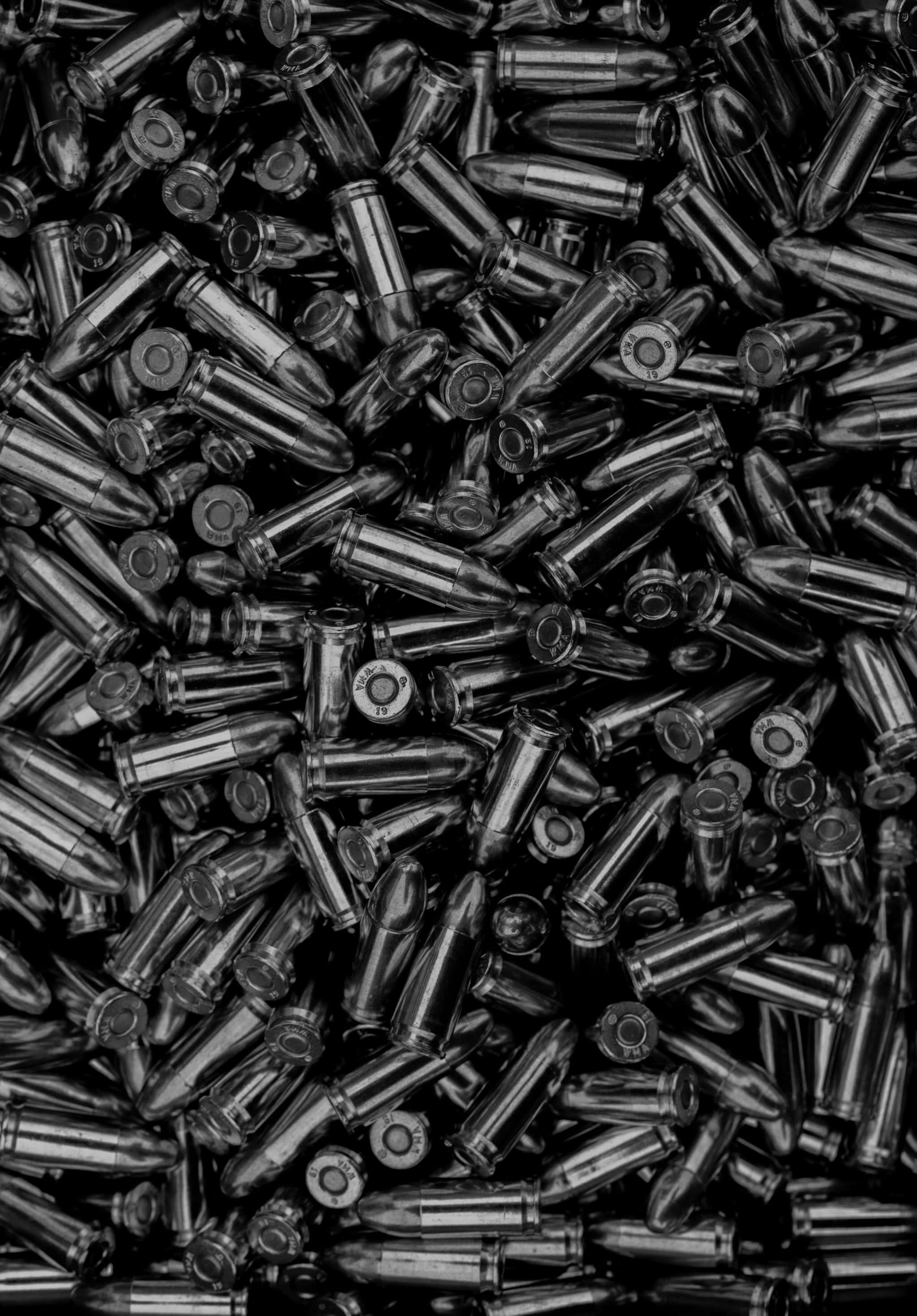 bullet 桌布 壁紙 — 密集的單色金屬子彈堆，以混亂的特寫細節散落。