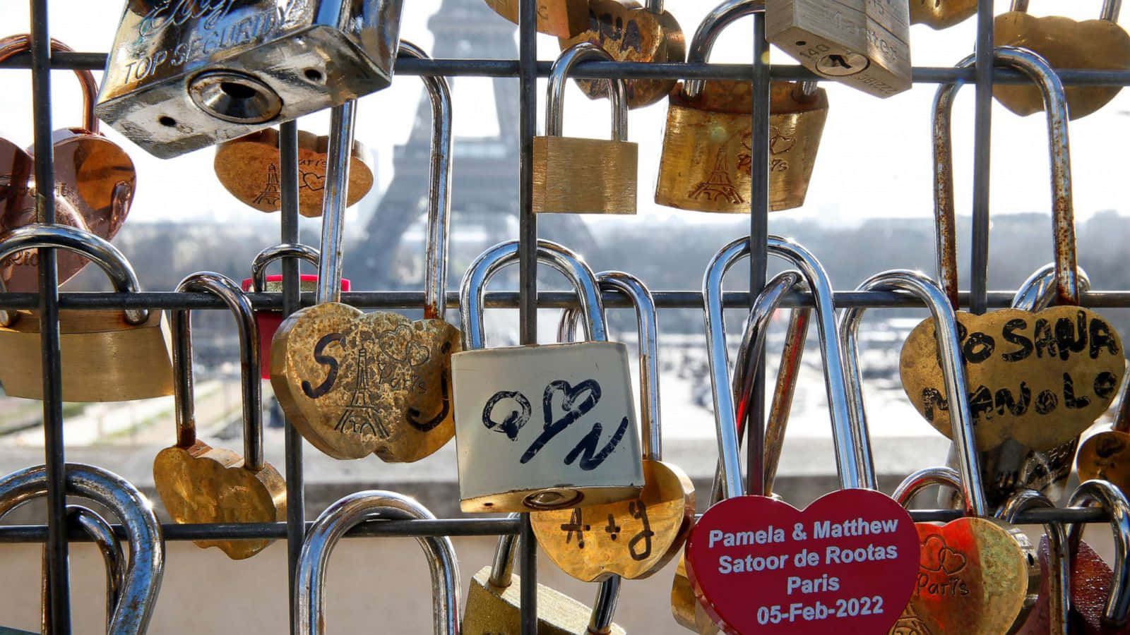 Locks 桌布 壁紙 — 密集的心形和金屬愛情鎖裝飾著欄杆，背景中隱約可見艾菲爾鐵塔。