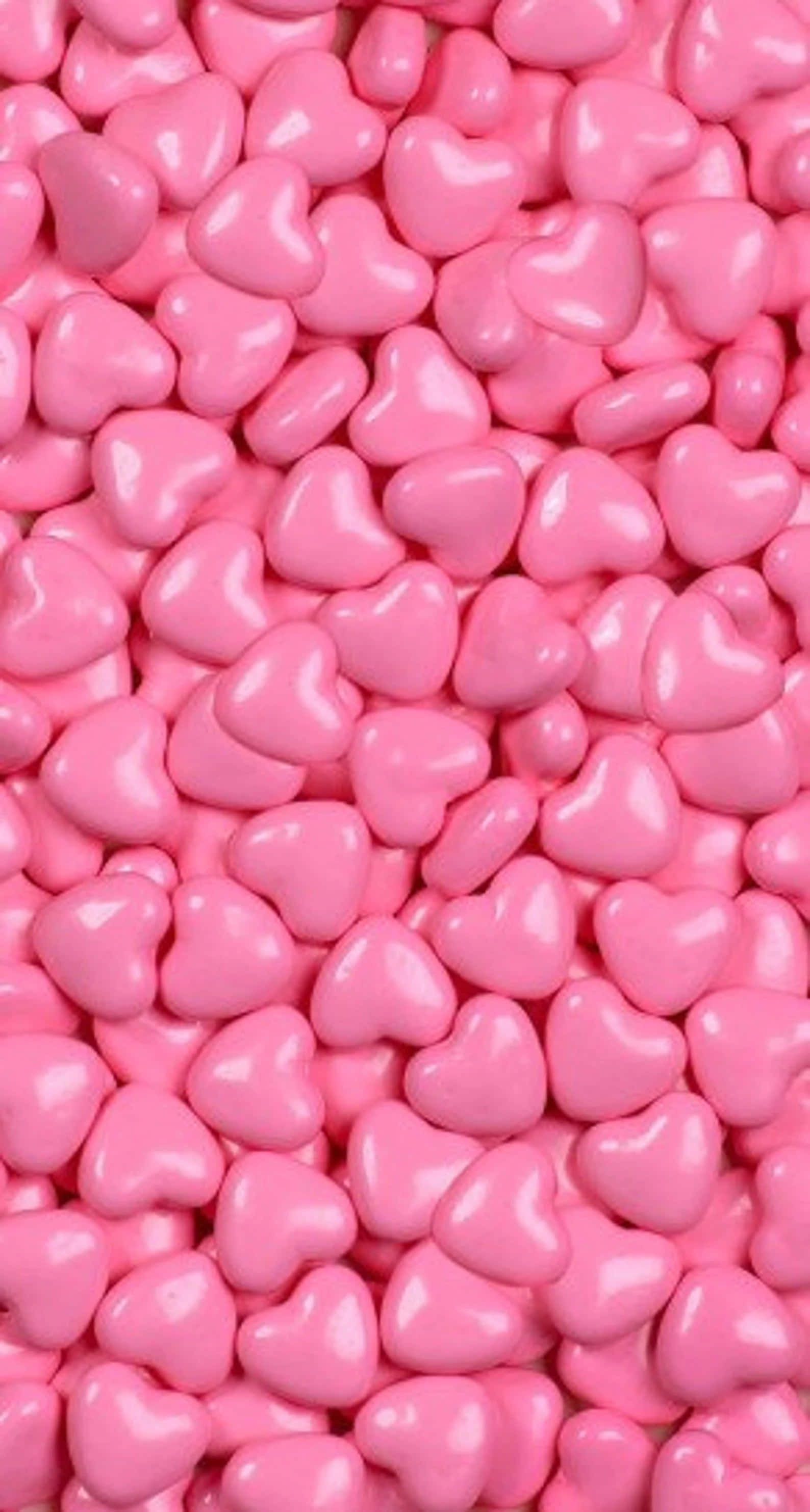 Pink Candy 桌布 壁紙 — 密集的粉紅色心形糖果佈滿畫面，帶有柔和的光線反射。