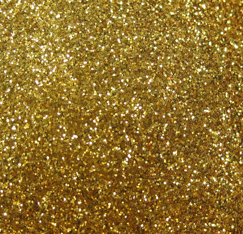 High Resolution Gold Glitter 桌布 壁紙 — 密集的金色閃粉粒子場，捕捉光線，帶有明亮的白色閃光。