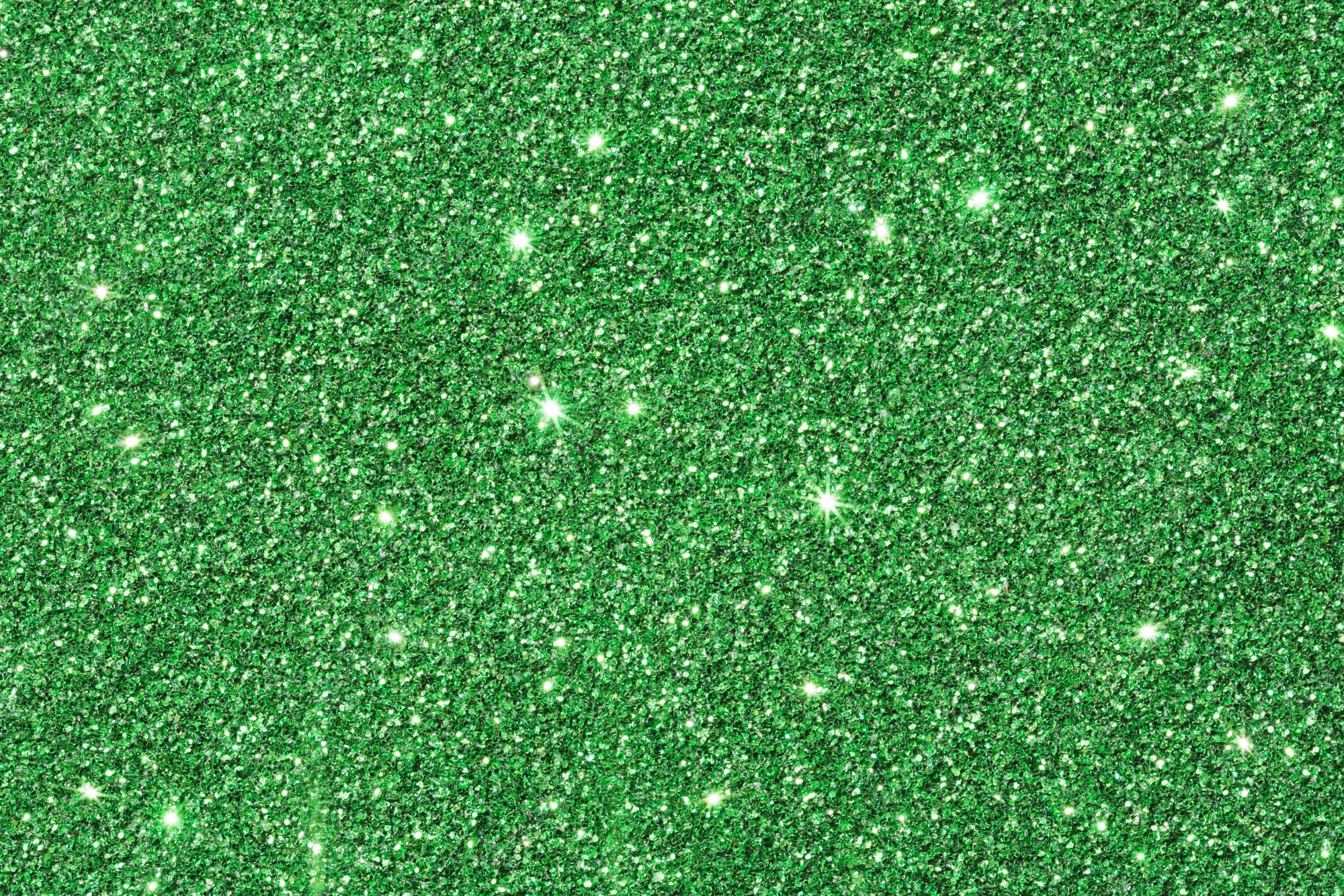 Green Glitter 桌布 壁紙 — 密集的鮮綠色閃粉粒子在直接光線下閃爍著明亮的白色高光。