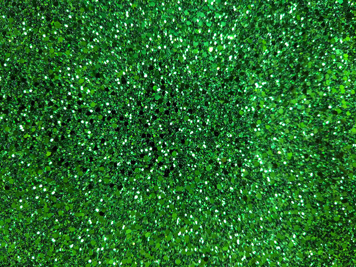 Green Glitter 桌布 壁紙 — 密集的鮮綠色閃粉粒子在黑暗背景上閃爍。