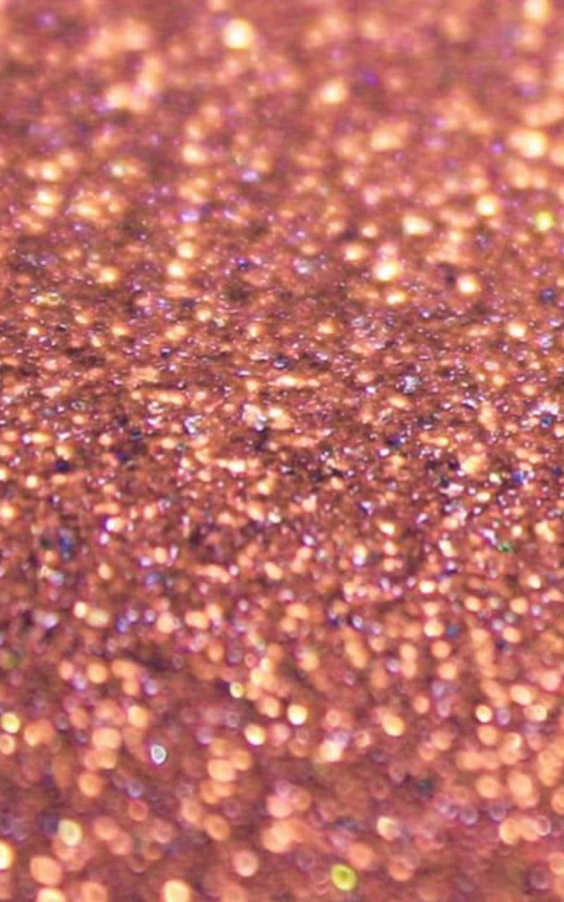 Glitter Rose Gold 桌布 壁紙 — 密集銅色閃粉的微距拍攝，散落虹彩閃片捕捉光線。