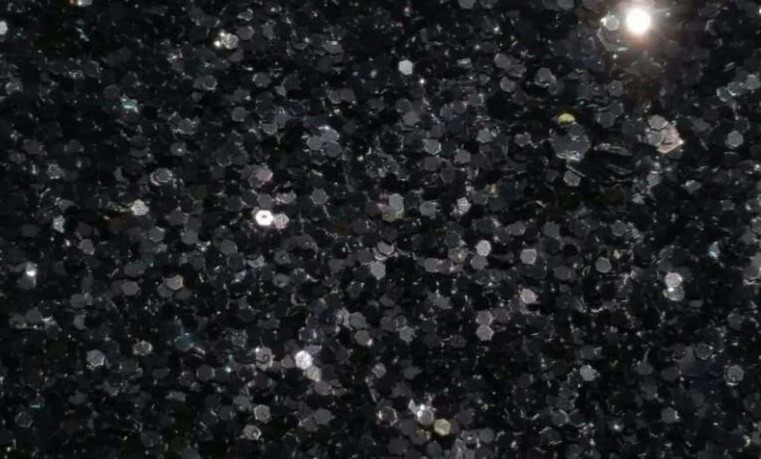 閃爍 桌布 壁紙 — 密集黑色六角形亮粉的特寫，帶有明亮的銀色閃光捕捉光線。