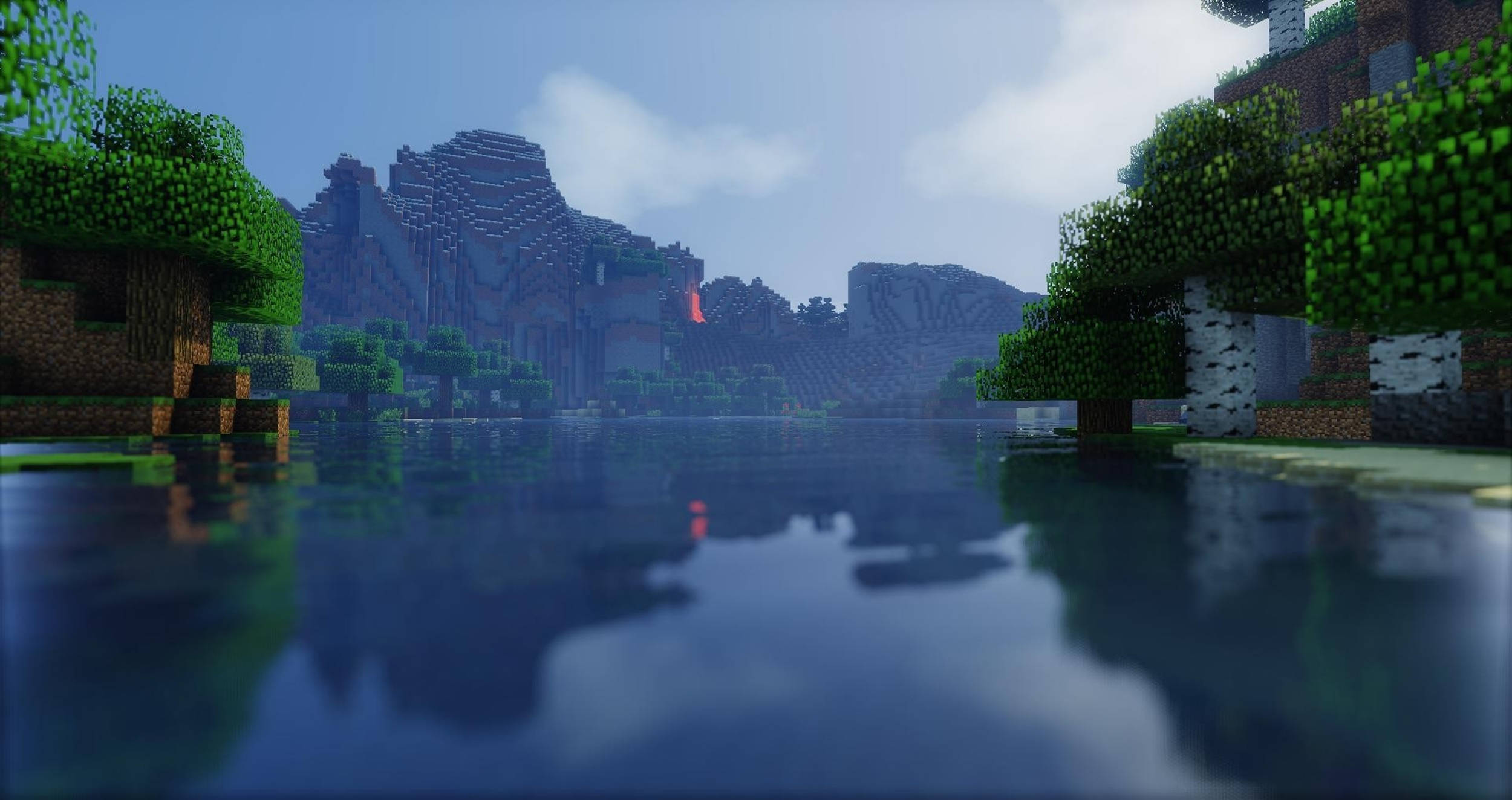 電玩遊戲 桌布 壁紙 — 寧靜的Minecraft風景，有方塊樹木和山脈倒映在平靜的水面，天空是柔和的藍色。