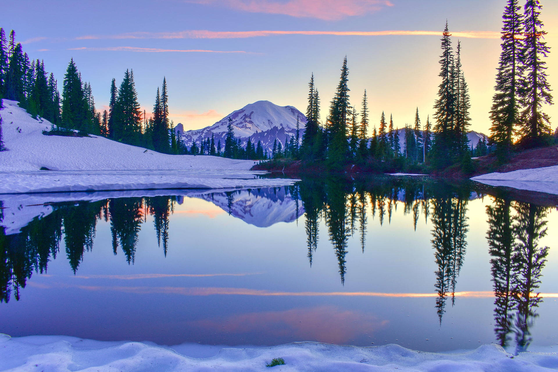 Washington 桌布 壁紙 — 寧靜的冬日湖泊映照著積雪的山峰和常綠樹，天空呈現柔和的日出色彩。