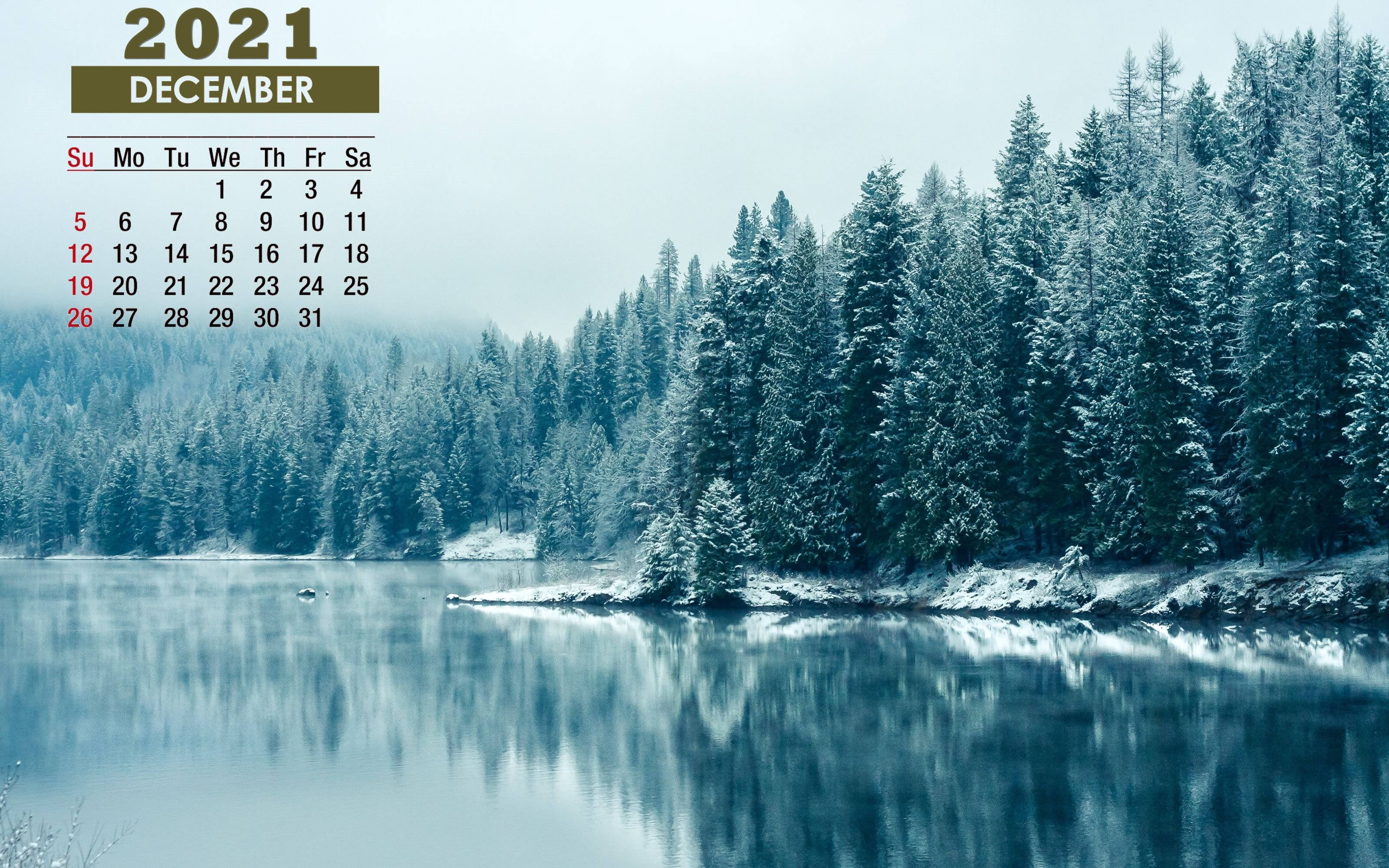 2021 Calendar 桌布 壁紙 — 寧靜的冬日湖面倒映著白雪覆蓋的松樹，灰濛濛的天空下覆蓋著2021年12月的日曆疊加層。