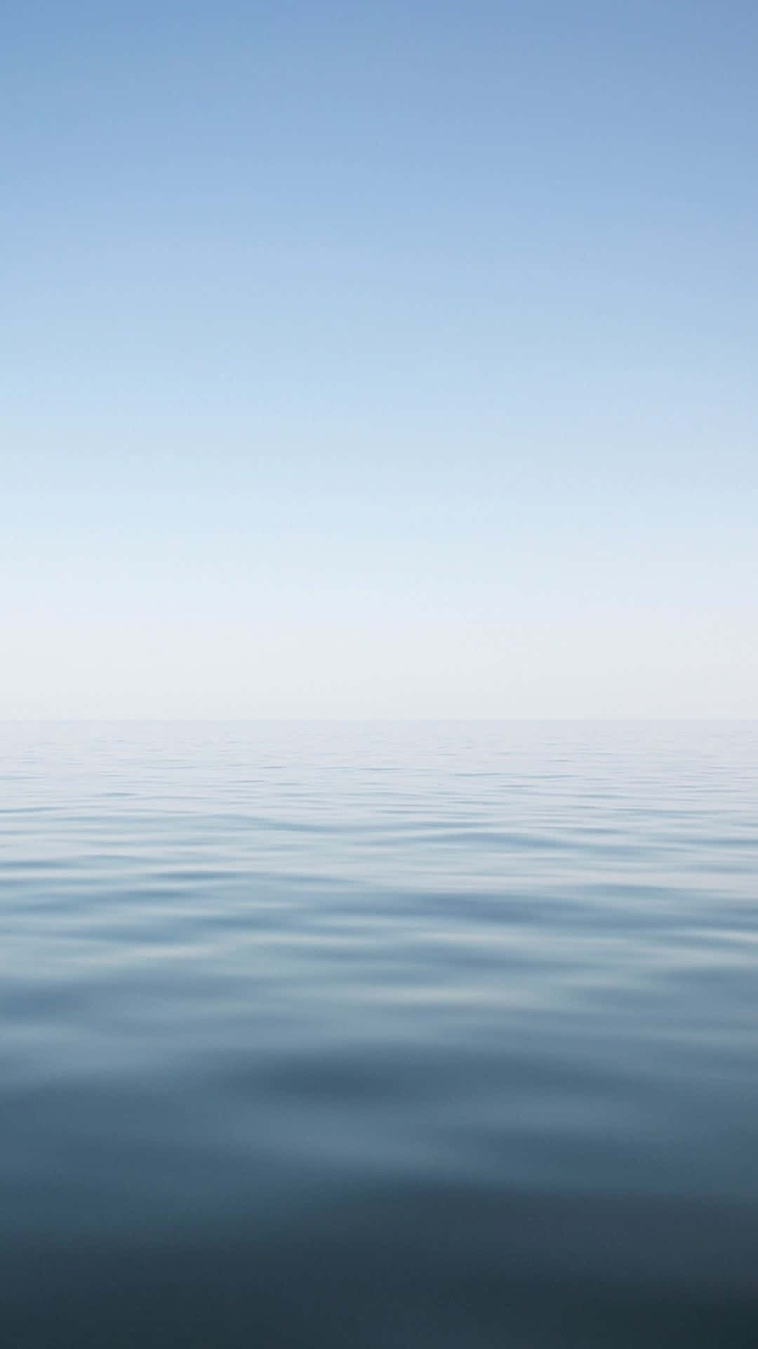Calming iPhone 桌布 壁紙 — 寧靜的地平線，平靜的藍色海水與清澈的天空以柔和漸變色調相遇。