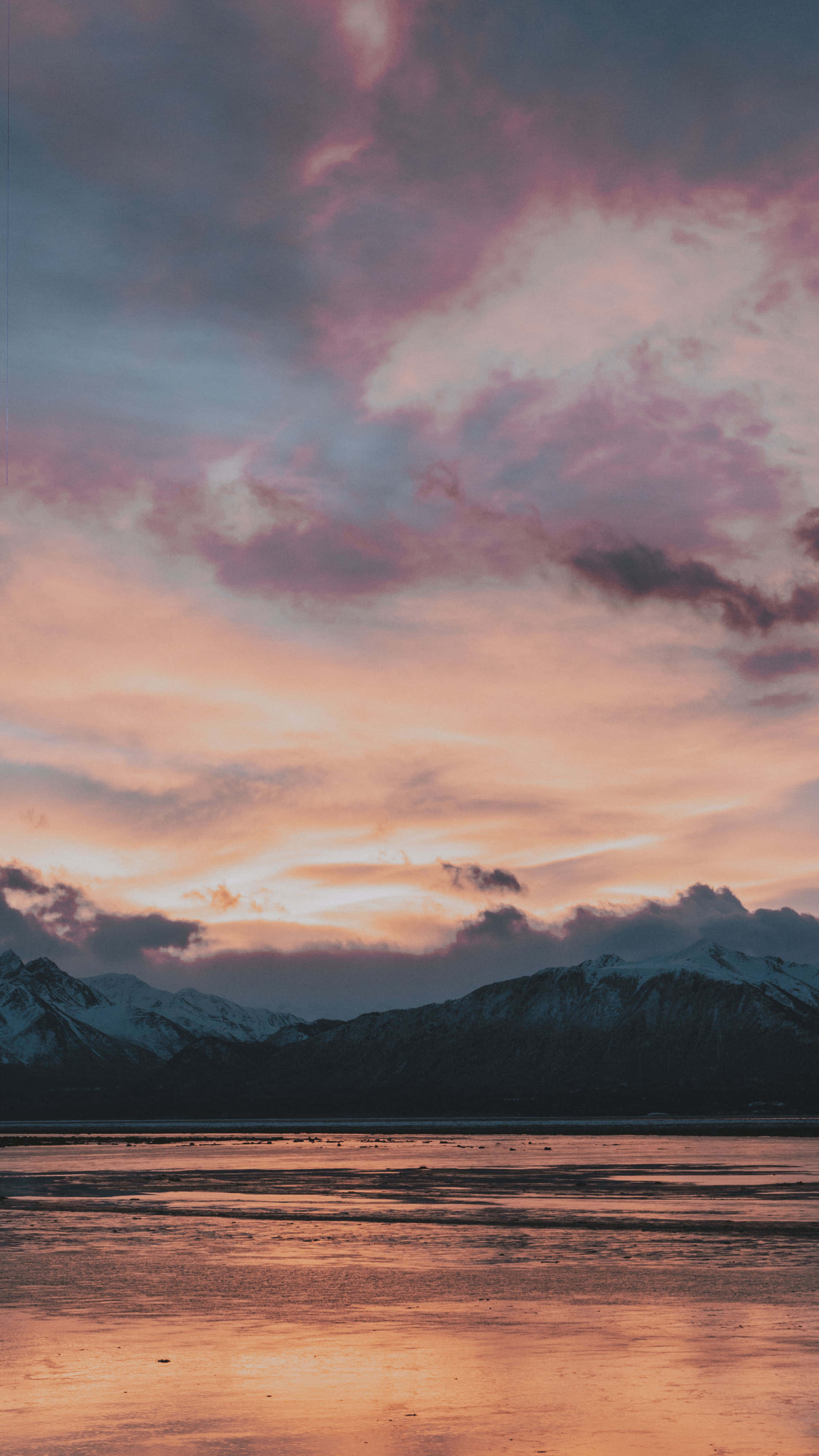 桌布 壁紙 — 寧靜的夕陽在平靜的湖面倒映的雪山之上，將天空染成粉紅色和橙色的色調。