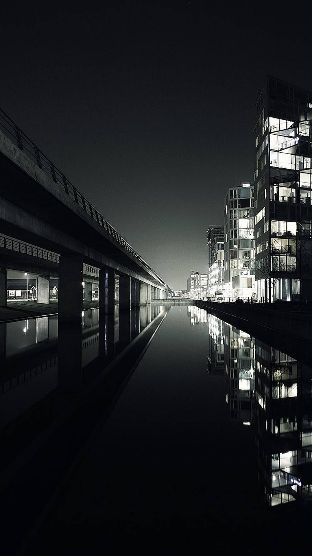 夜晚城市，發光的建築物在平靜的運河中倒映。 — 黑暗城市 壁紙