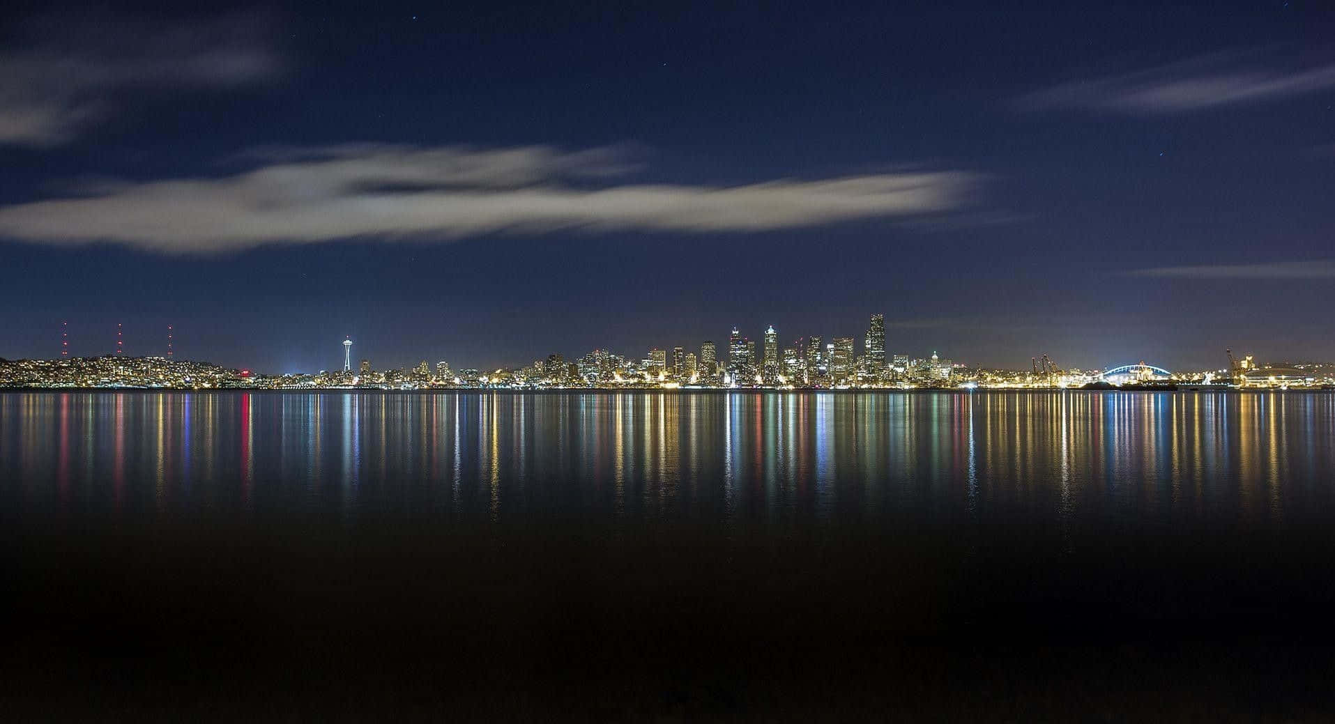 Seattle Washington 桌布 壁紙 — 寧靜的夜景，城市天際線倒映在平靜的水面上，星空點綴，薄雲飄逸。