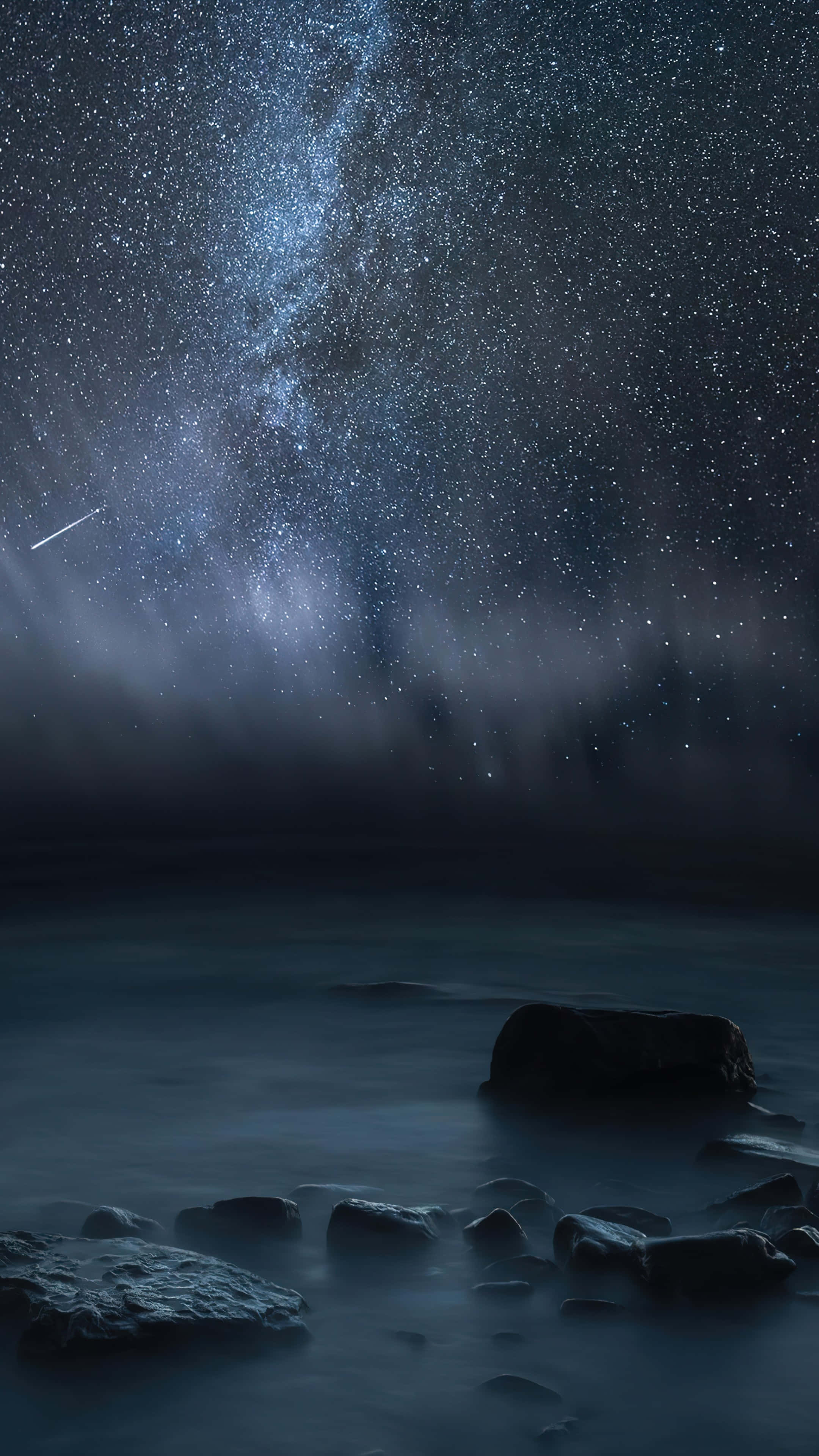 諾基亞 桌布 壁紙 — 寧靜的夜景，星空和銀河拱起在霧氣瀰漫的海洋上，前景有深色岩石。