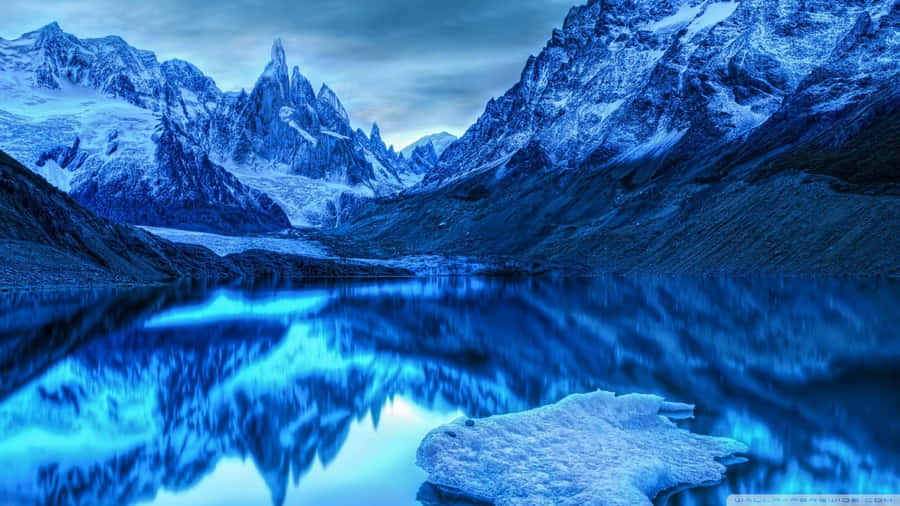 Cool Landscape 桌布 壁紙 — 寧靜的山湖在暮色天空下映照著白雪覆蓋的山峰，帶有冰冷的倒影和漂浮的冰川碎片。