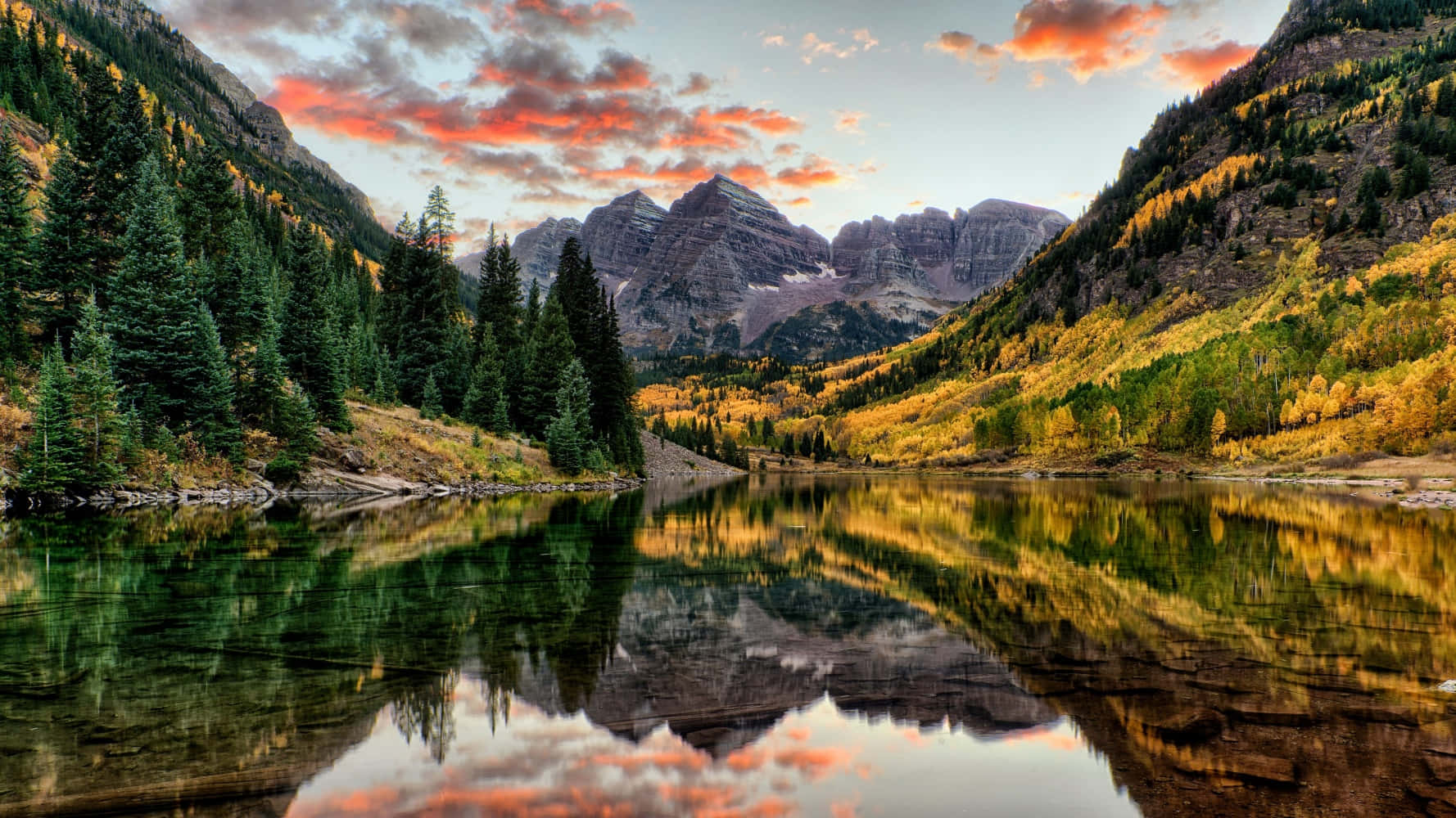 Colorado 桌布 壁紙 — 寧靜的山湖映照著熾熱的日落雲彩和秋色森林，背景是崎嶇的山峰。