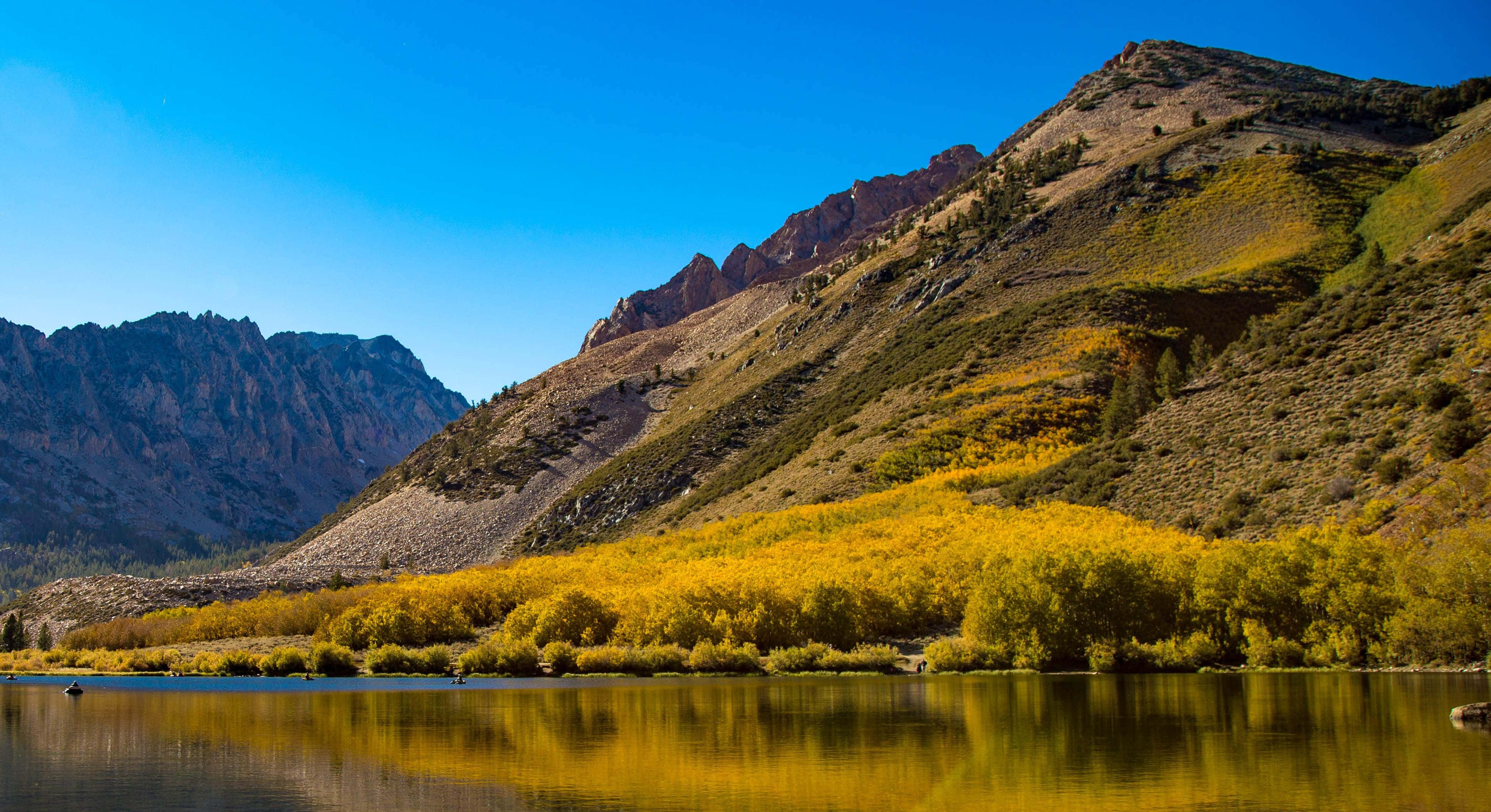 High Sierra 桌布 壁紙 — 寧靜的山湖映照著金色白楊樹，背景是清澈藍天和崎嶇山峰。