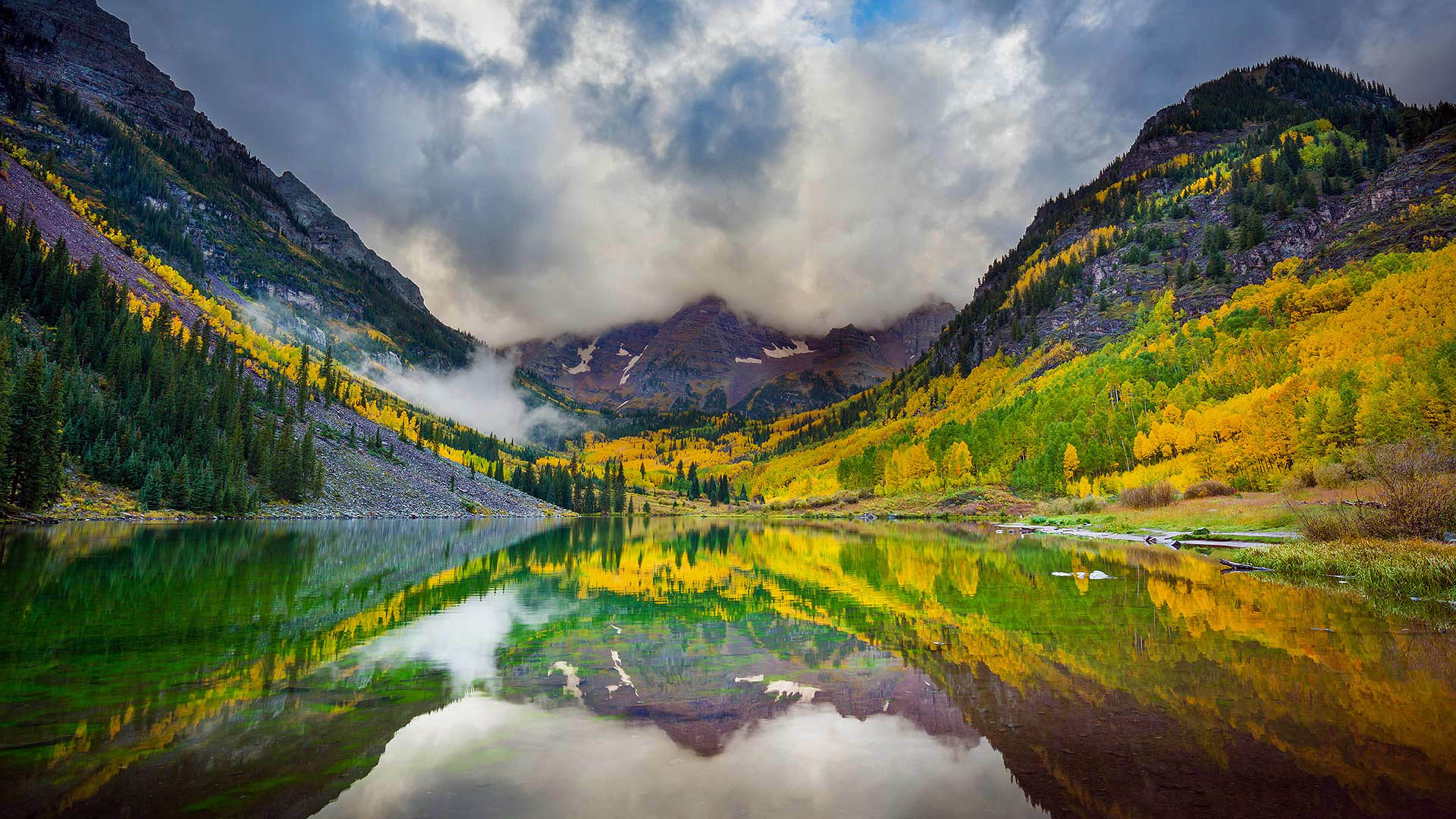 Colorado 桌布 壁紙 — 寧靜的山湖映照著金色的白楊樹和霧氣籠罩的山峰，天空佈滿戲劇性的雲層。