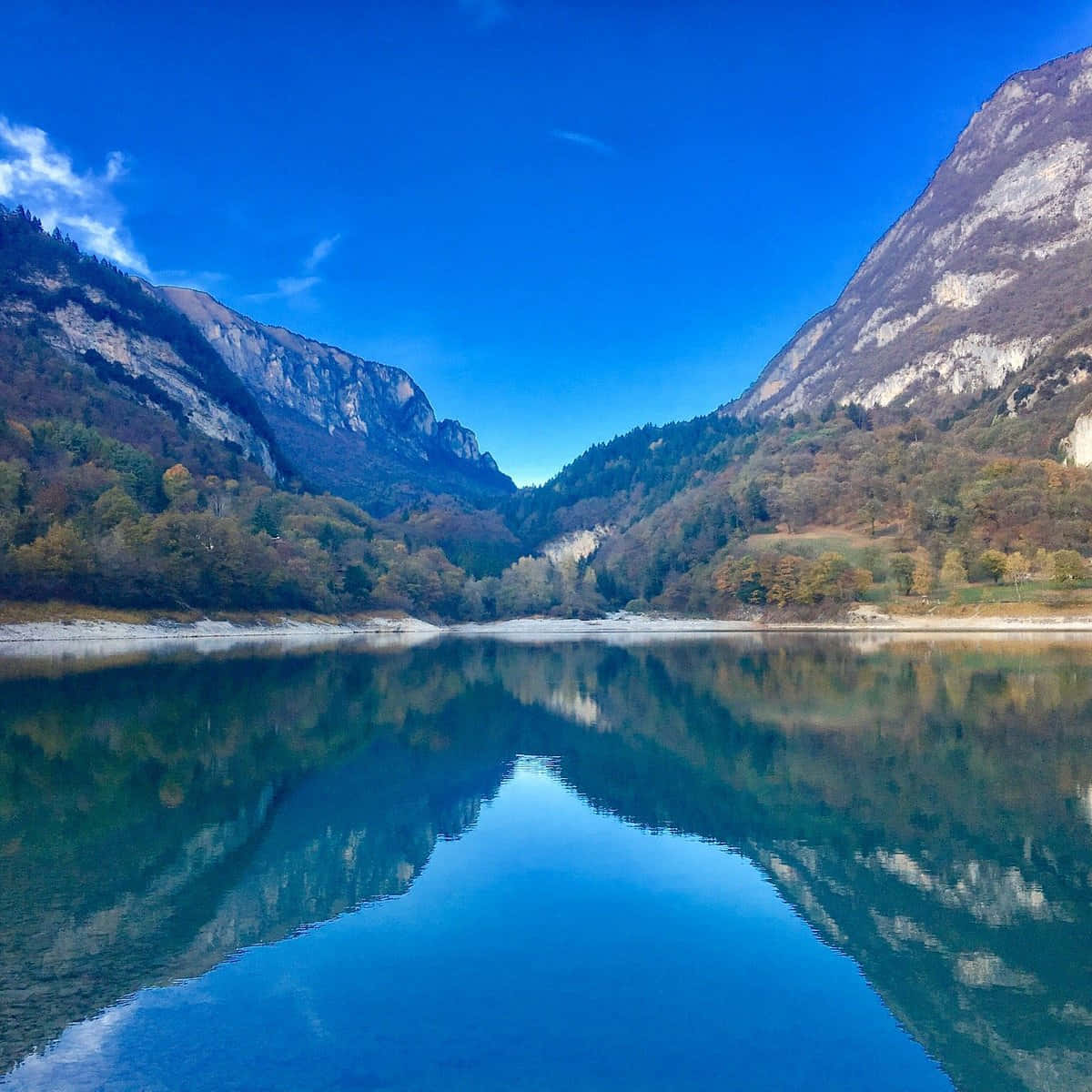 Lake 桌布 壁紙 — 寧靜的山湖映照著高聳的懸崖和秋樹，在清澈的藍天下。