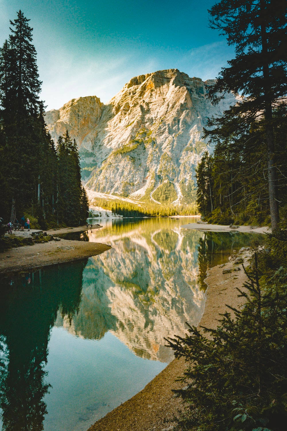 Landscapes 桌布 壁紙 — 寧靜的山間湖泊映照出高聳的岩石山峰和茂密的松樹林，天空湛藍清澈。