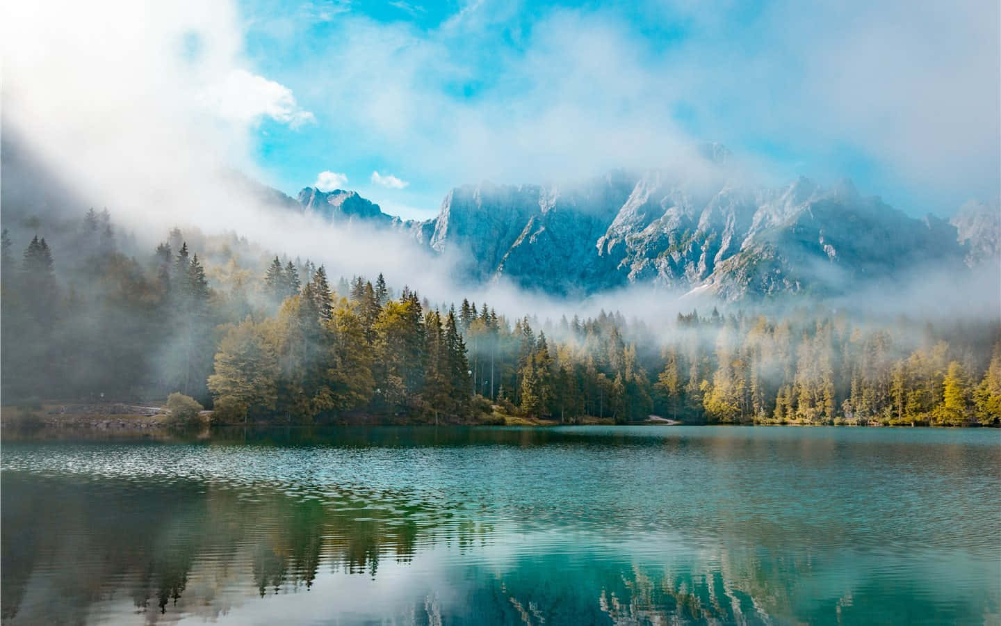 Lake 桌布 壁紙 — 寧靜的山間湖泊映照著霧氣籠罩的山峰和秋樹，在明亮的藍天下。