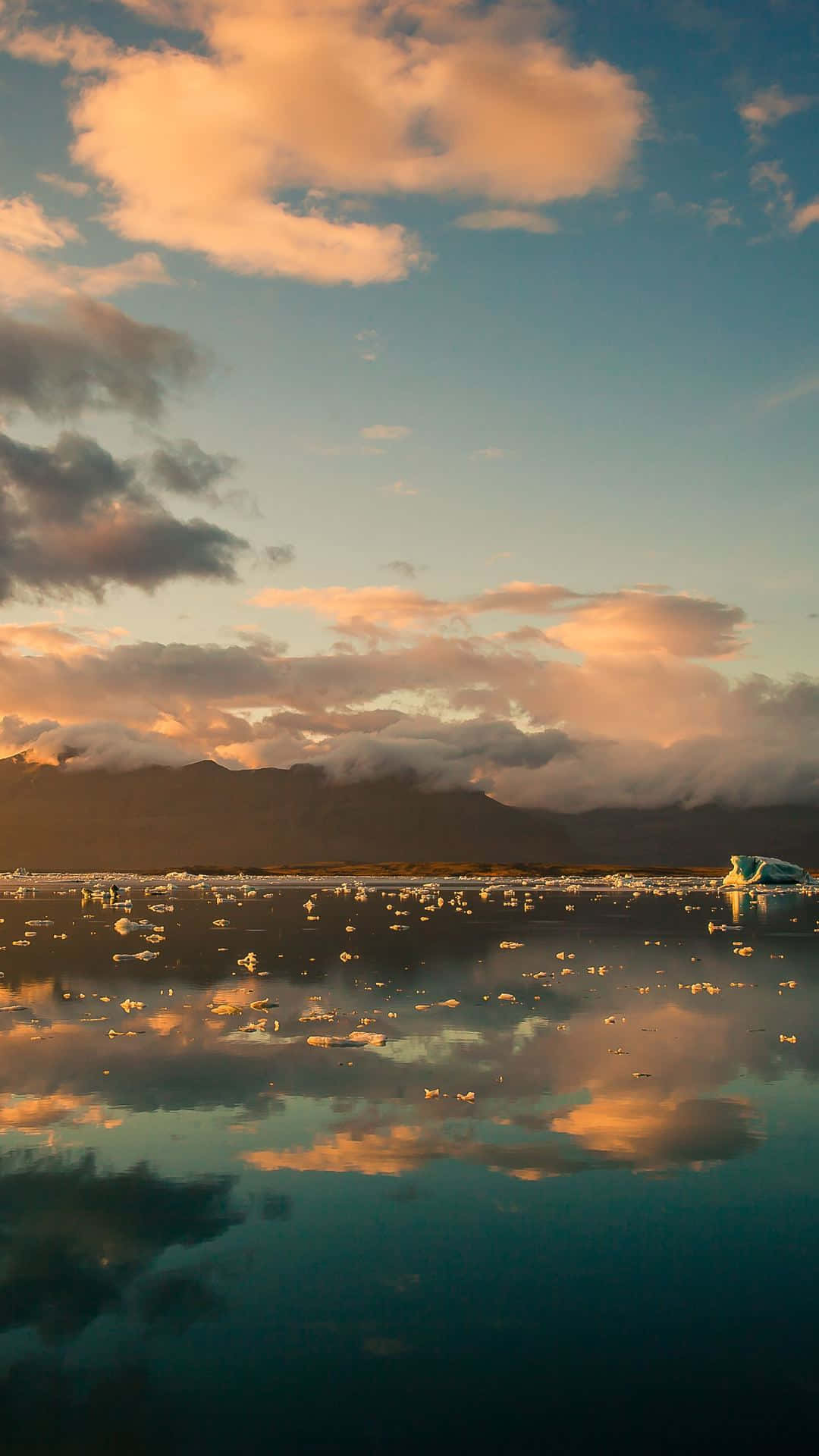 Clouds Aesthetic Tumblr 桌布 壁紙 — 寧靜的日落映照在冰川湖上，浮冰和雲朵倒映在平靜的水面。