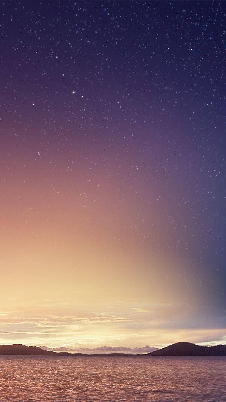 Xiaomi 桌布 壁紙 — 寧靜的暮色天空從深紫色過渡到溫暖的橙色，籠罩著平靜的海面和遠處的輪廓山丘。