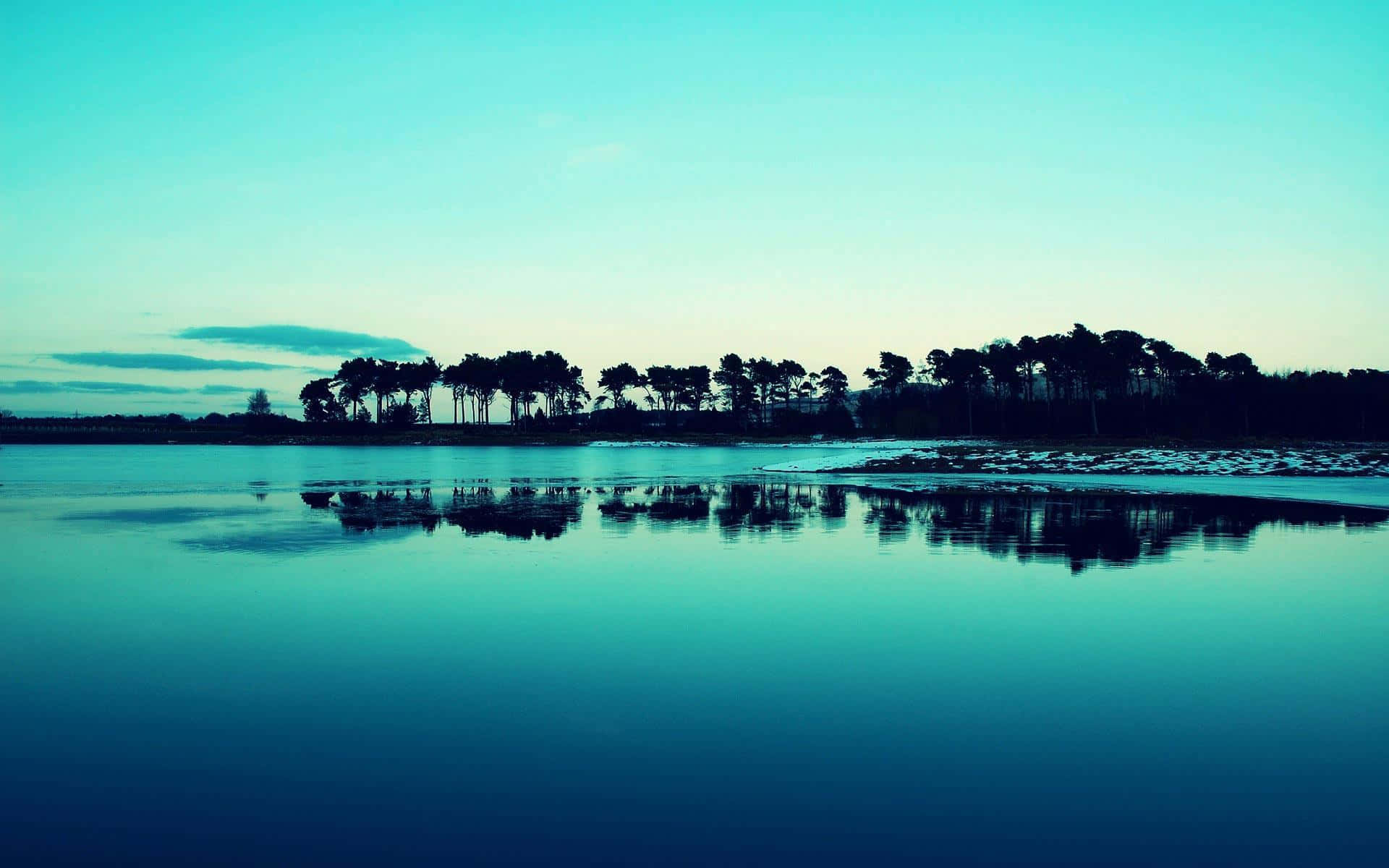 Calming Desktop 桌布 壁紙 — 寧靜的暮色湖泊映照出松樹林的剪影，天空呈現漸變的藍綠色。