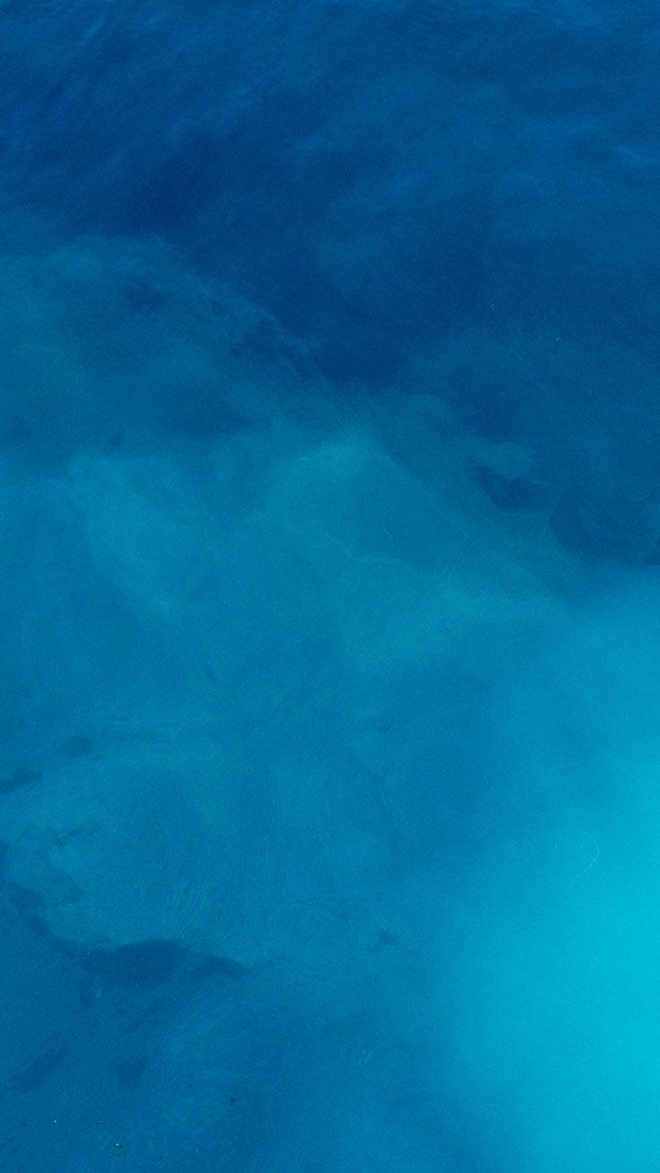 Blue iPhone 桌布 壁紙 — 寧靜的水下景觀，呈現變化的碧綠和深藍色水流，並隱約可見海床紋理。