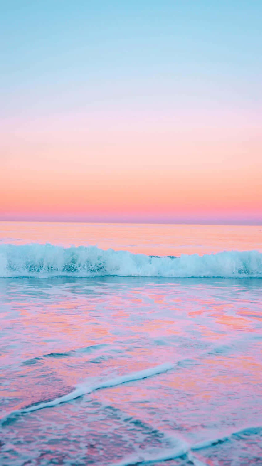 Beach Aesthetic Tumblr 桌布 壁紙 — 寧靜的海浪在日落時分拍打，粉紅、橙、藍色的粉彩天空倒映在水中。
