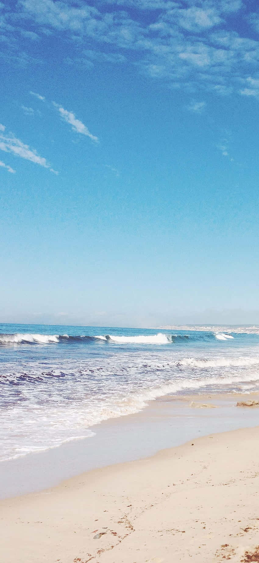 白色 桌布 壁紙 — 寧靜的海灘場景，碧綠色的海浪拍打著金色沙灘，廣闊的藍天中飄著縷縷白雲。