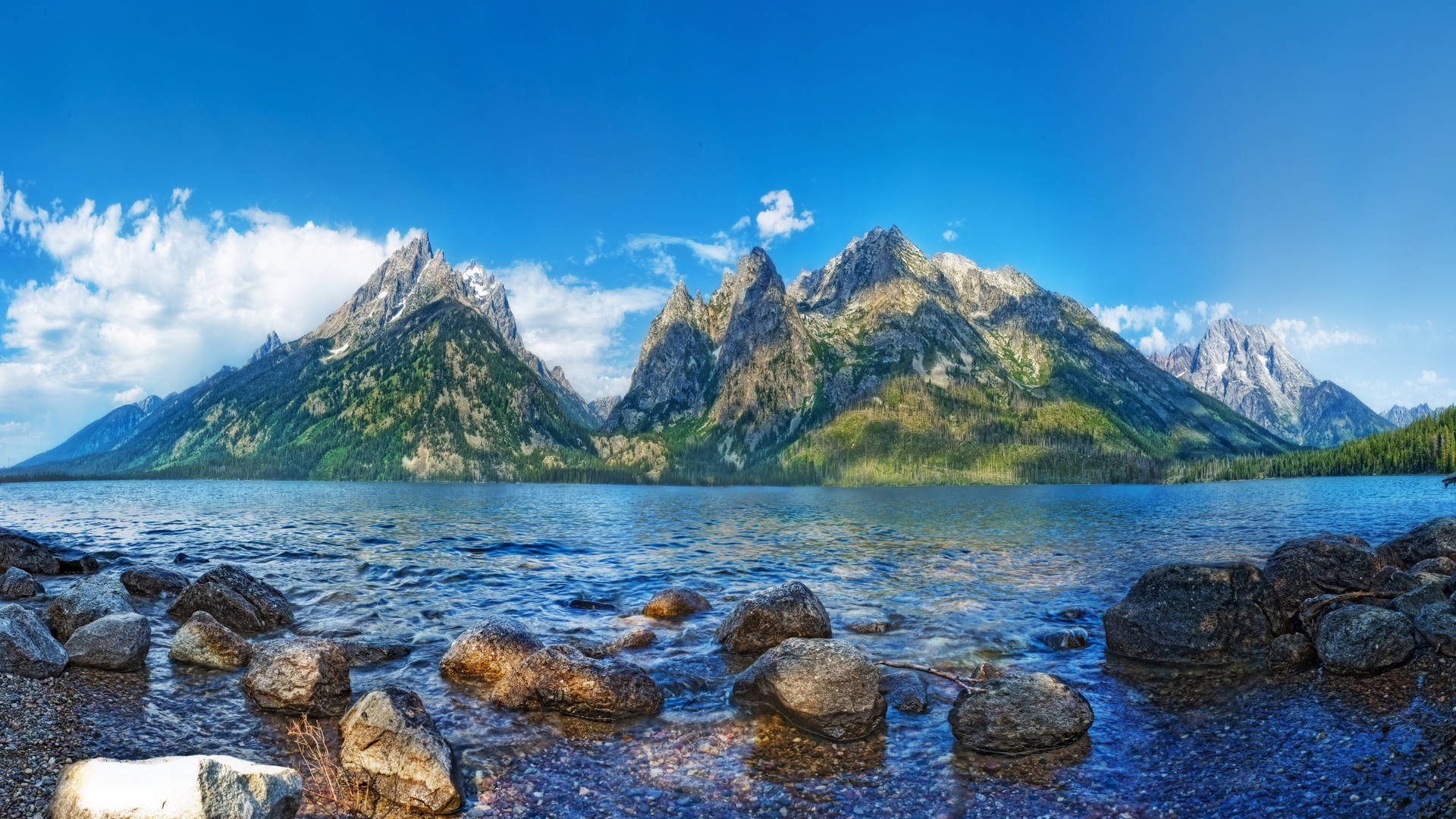平靜的湖泊，前景有大岩石，背景有雄偉的山脈。 — 8K 超高畫質 壁紙
