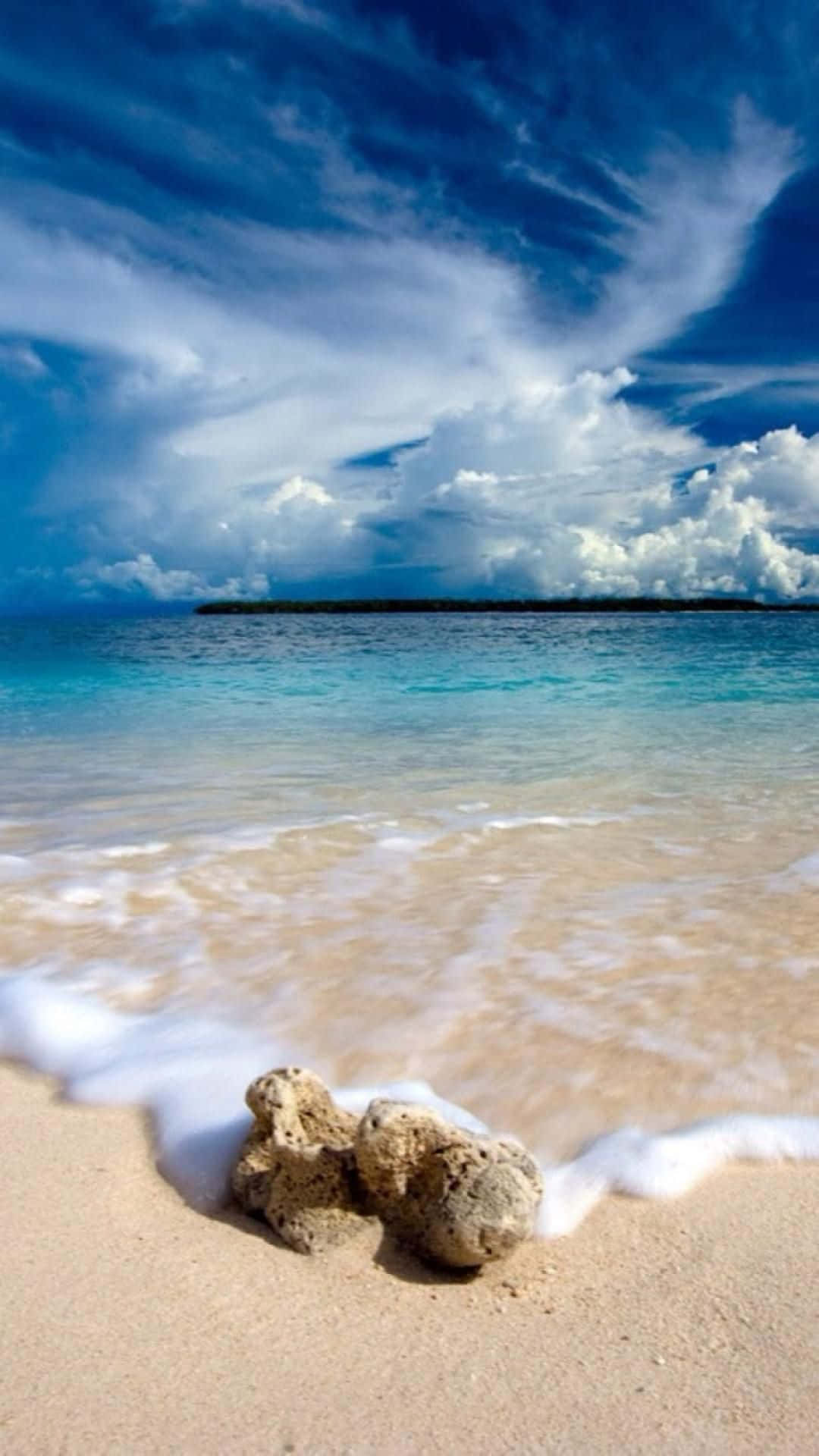 Beach Scene 桌布 壁紙 — 寧靜的熱帶海灘，碧綠的海浪拍打著金色的沙灘，上方是戲劇性的藍天和蓬鬆的白雲。