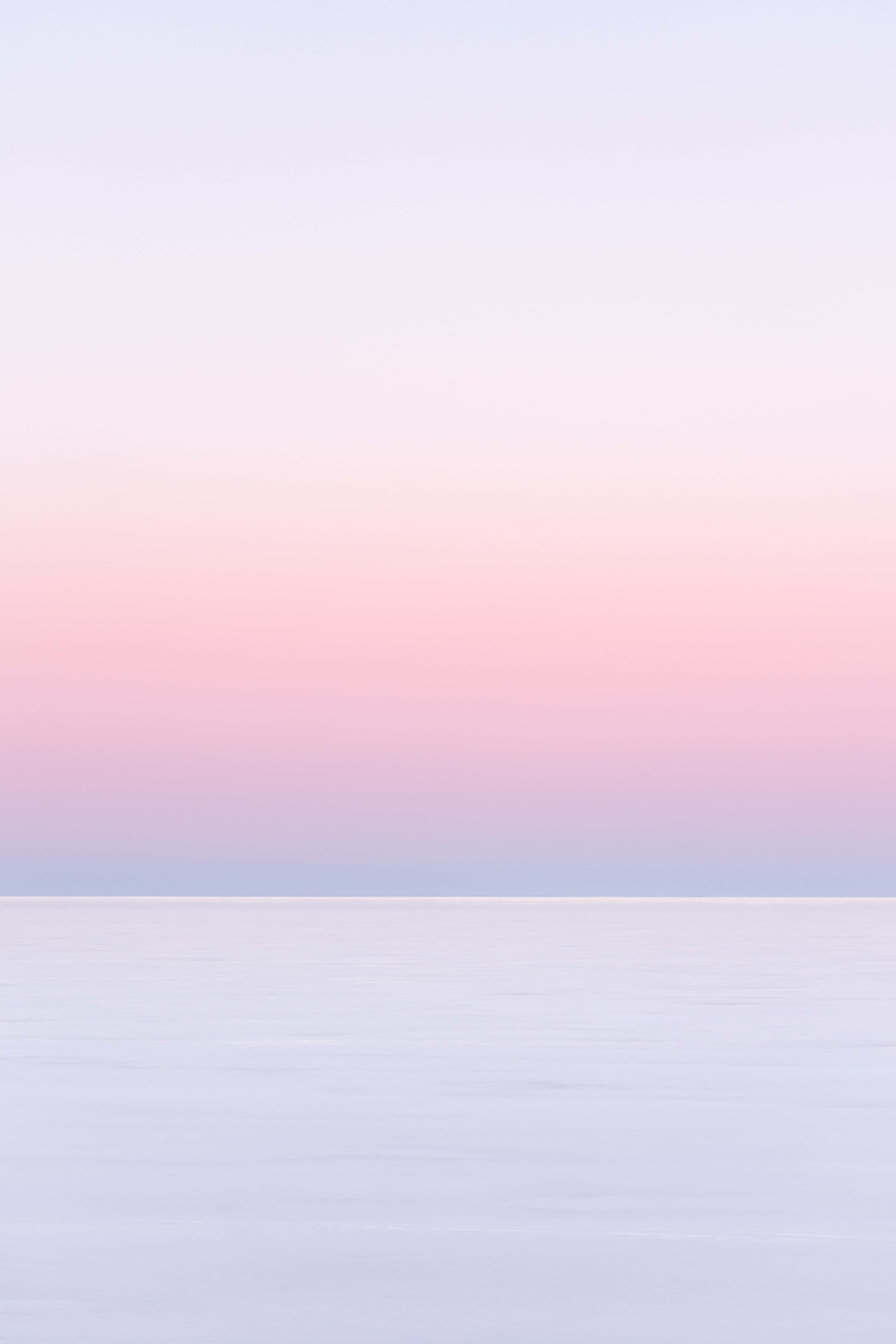 Pink Sky 桌布 壁紙 — 寧靜的粉彩漸變天空在暮色中從柔和的粉紅色過渡到薰衣草色，籠罩著平靜的冰凍湖泊。