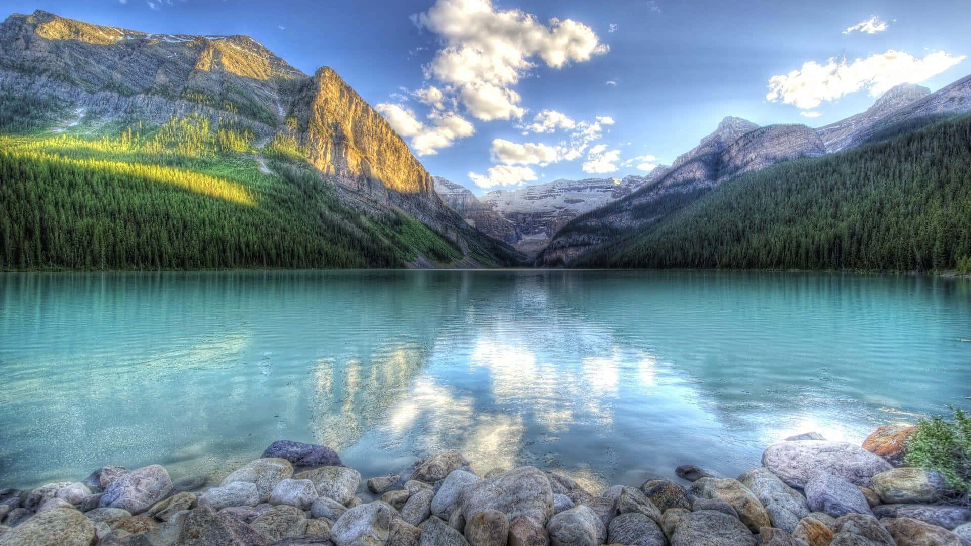 Lake 桌布 壁紙 — 寧靜的綠松石色湖泊倒映著白雪覆蓋的山脈和蓬鬆的雲朵，在明亮的藍天下。